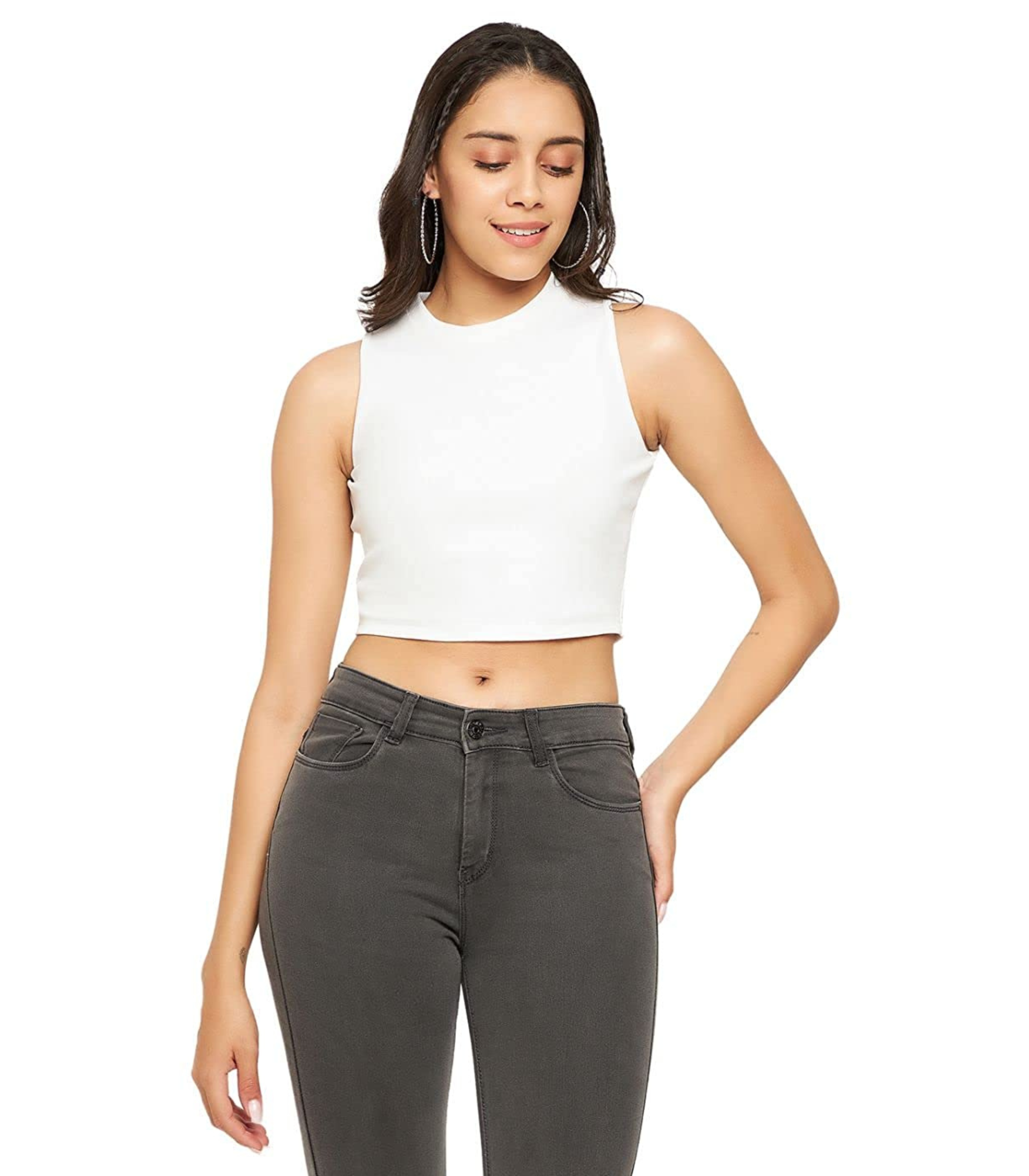 Woman wearing a white sleeveless top and gray jeans on a white background