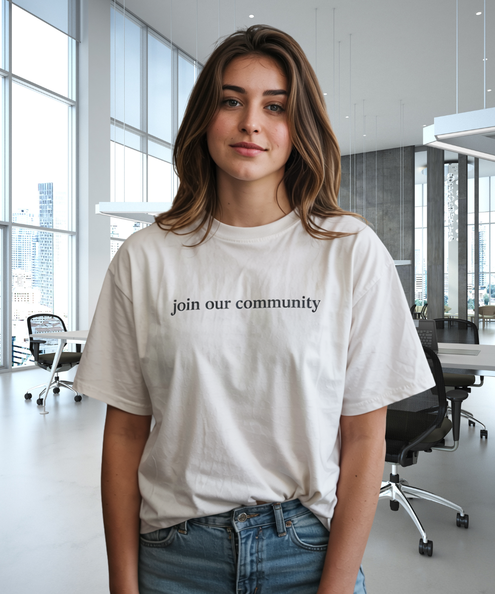 Person wearing a white t-shirt with 'join our community' text in an office setting