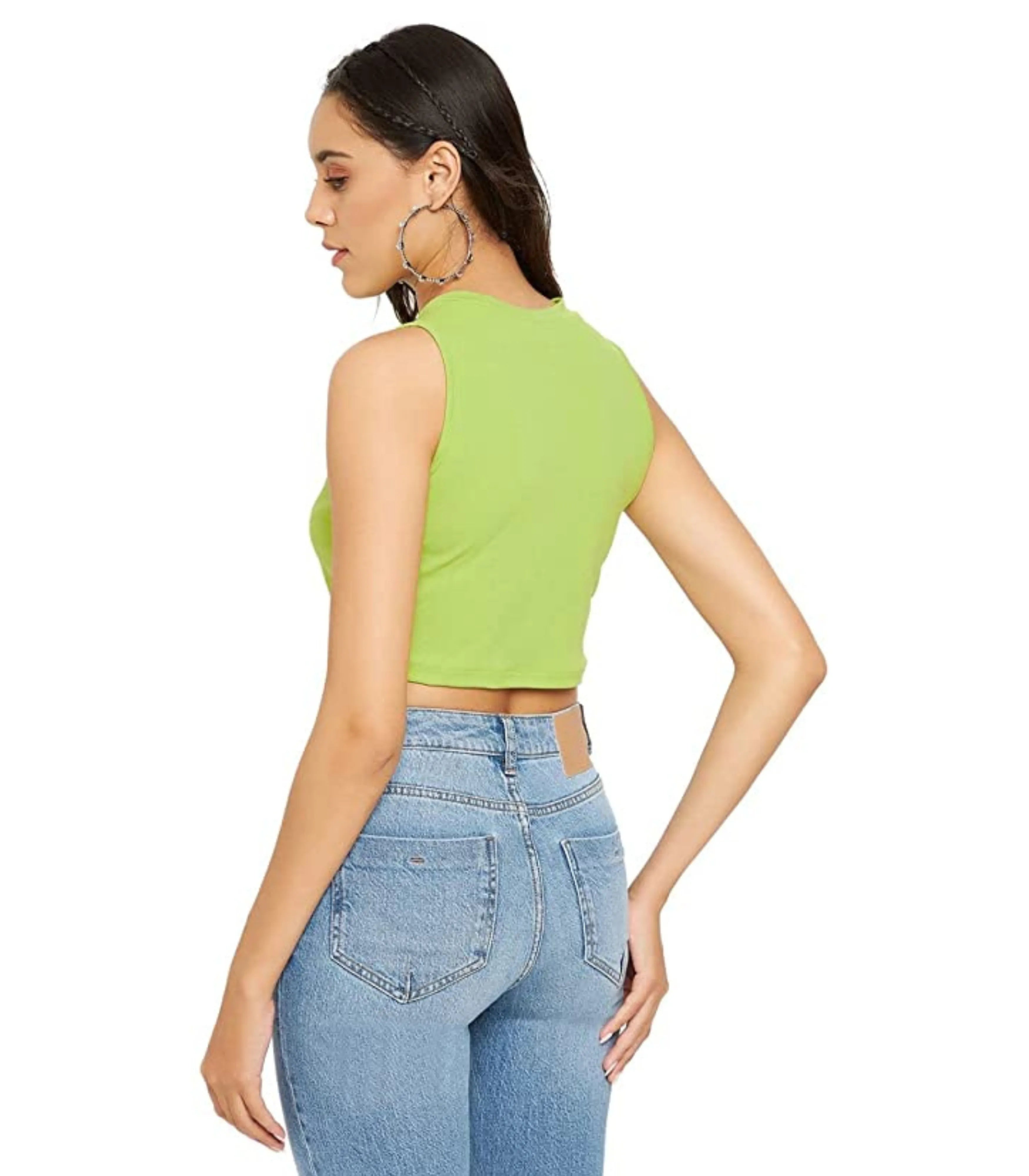 Woman wearing a green crop top and blue jeans on a white background