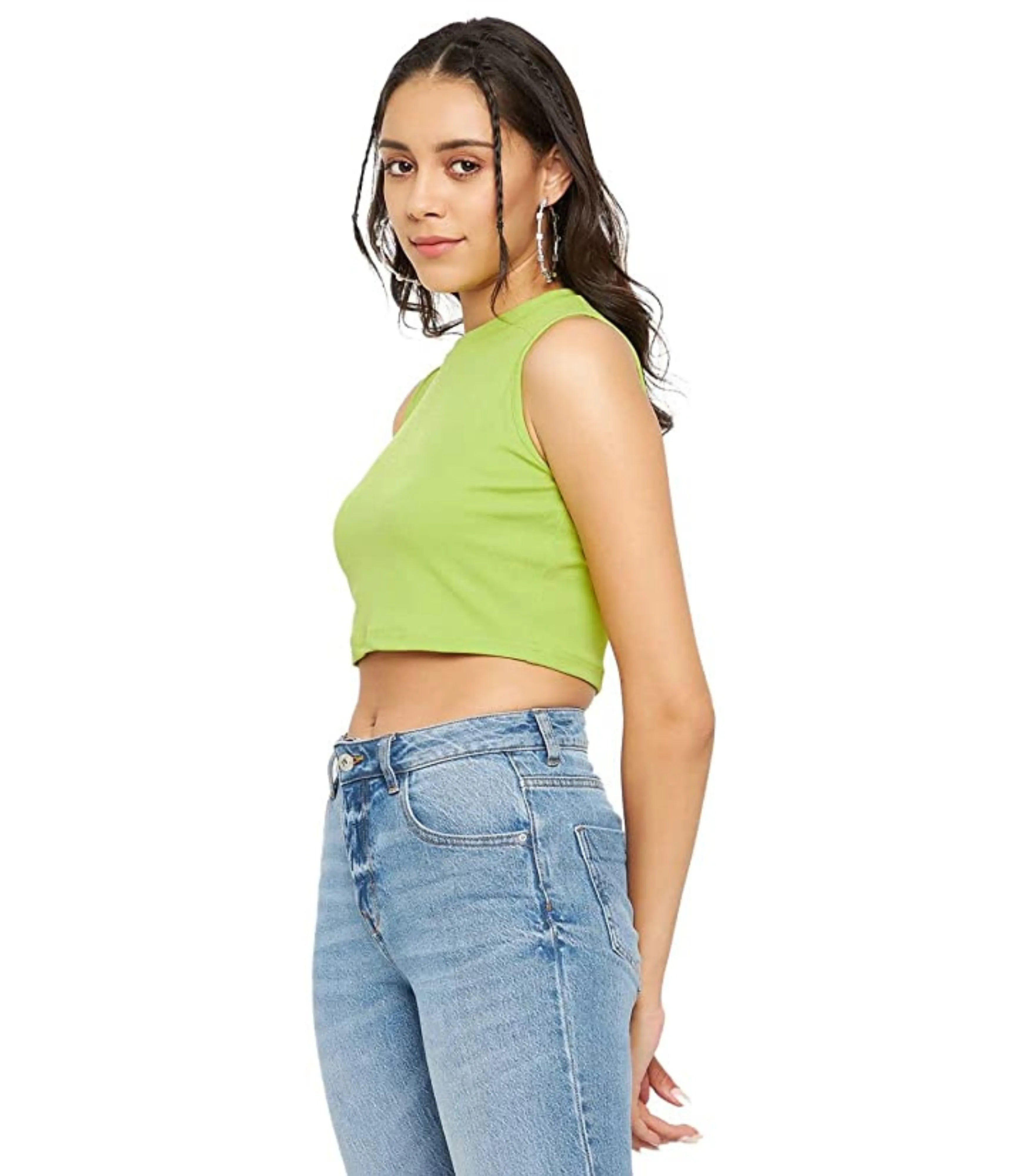 Woman wearing a green crop top and blue jeans on a white background