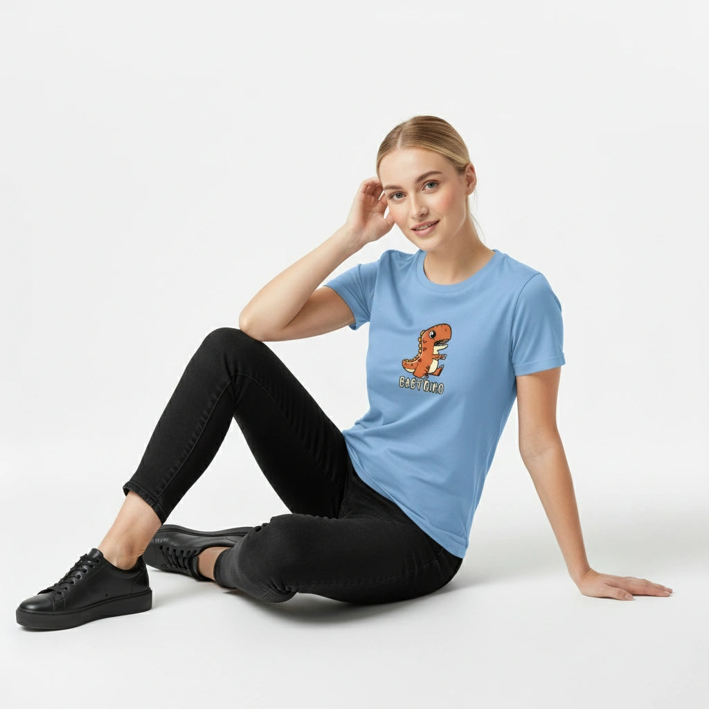 Woman wearing a light blue t-shirt with a dinosaur graphic sitting on a white background