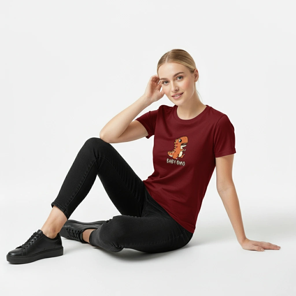 Woman wearing a maroon t-shirt with a graphic design sitting on a white background