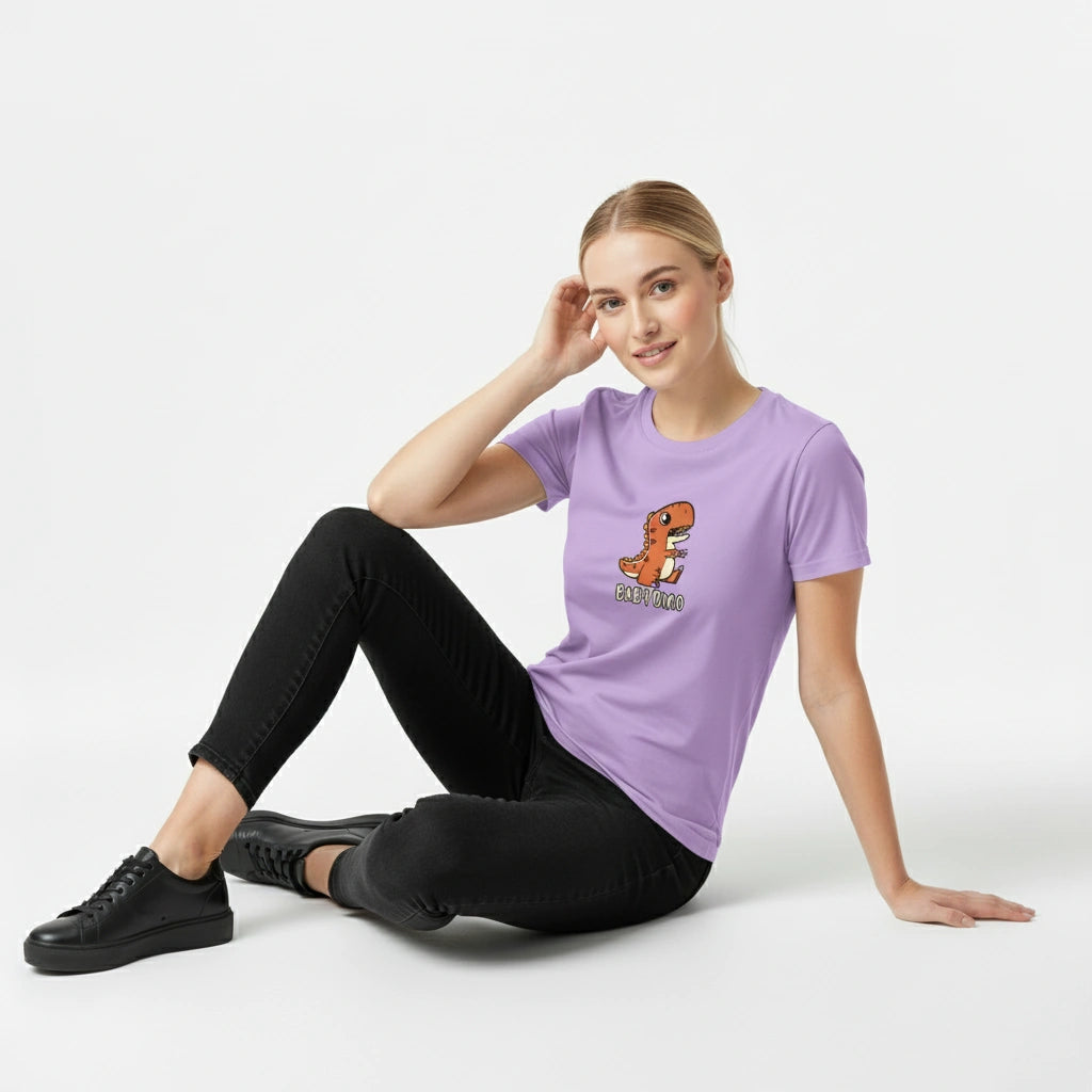 Woman wearing a purple t-shirt with a dinosaur graphic sitting on the floor against a white background