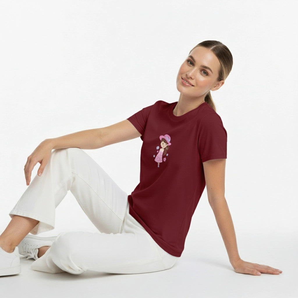 Woman wearing a maroon t-shirt with a graphic design sitting on a white background
