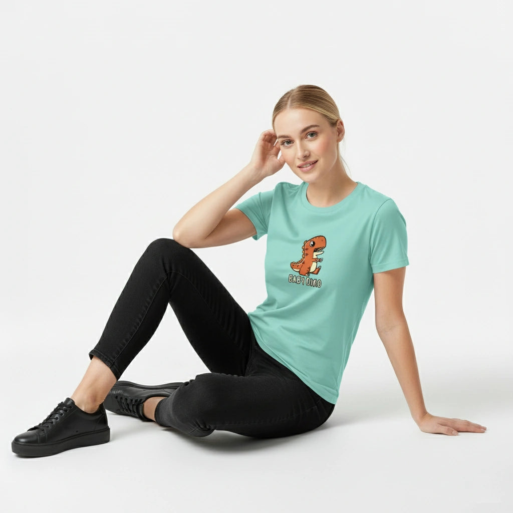 Woman wearing a light blue t-shirt with a dinosaur graphic sitting on a white background