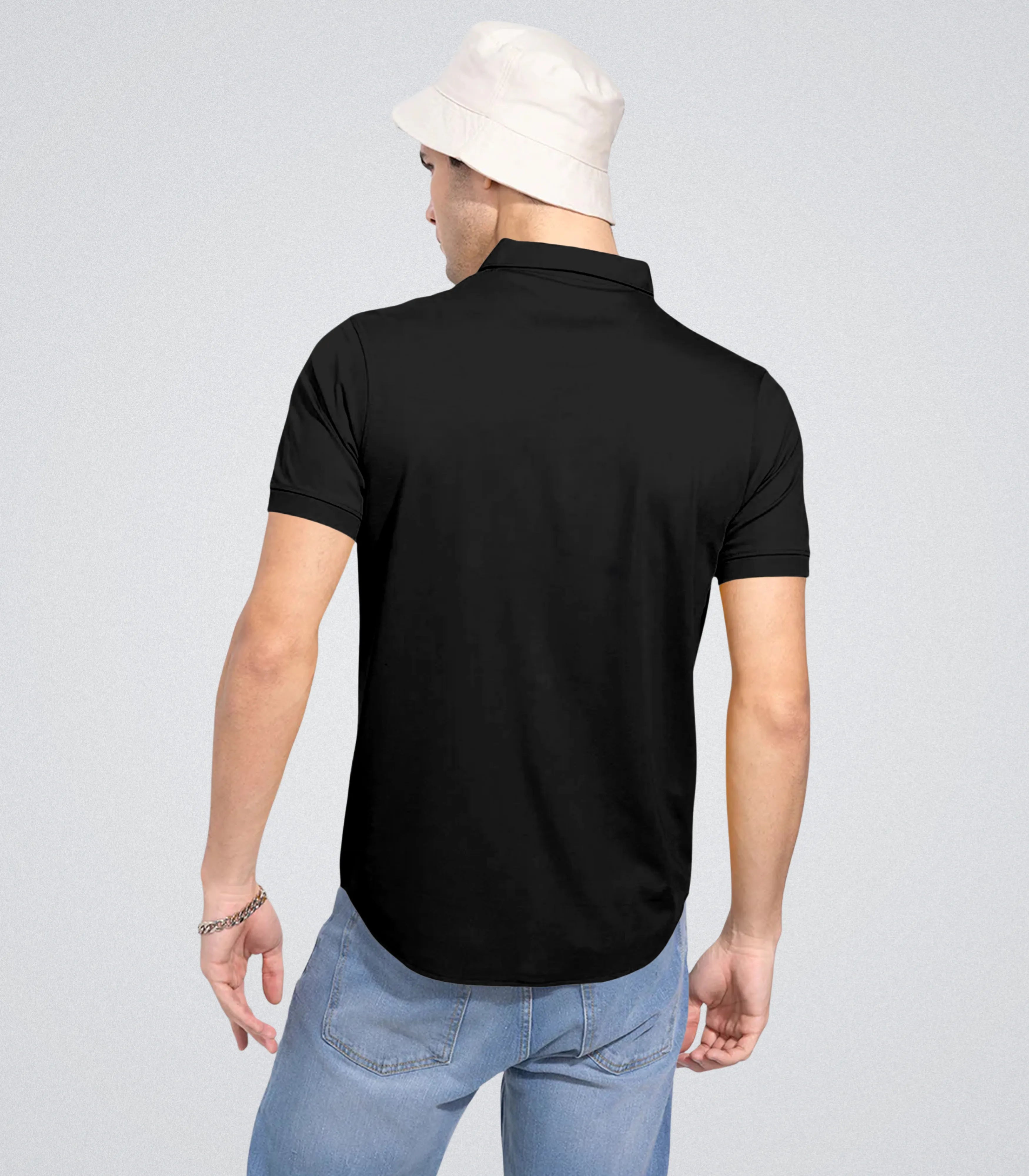 Person wearing a black polo shirt with a plain background