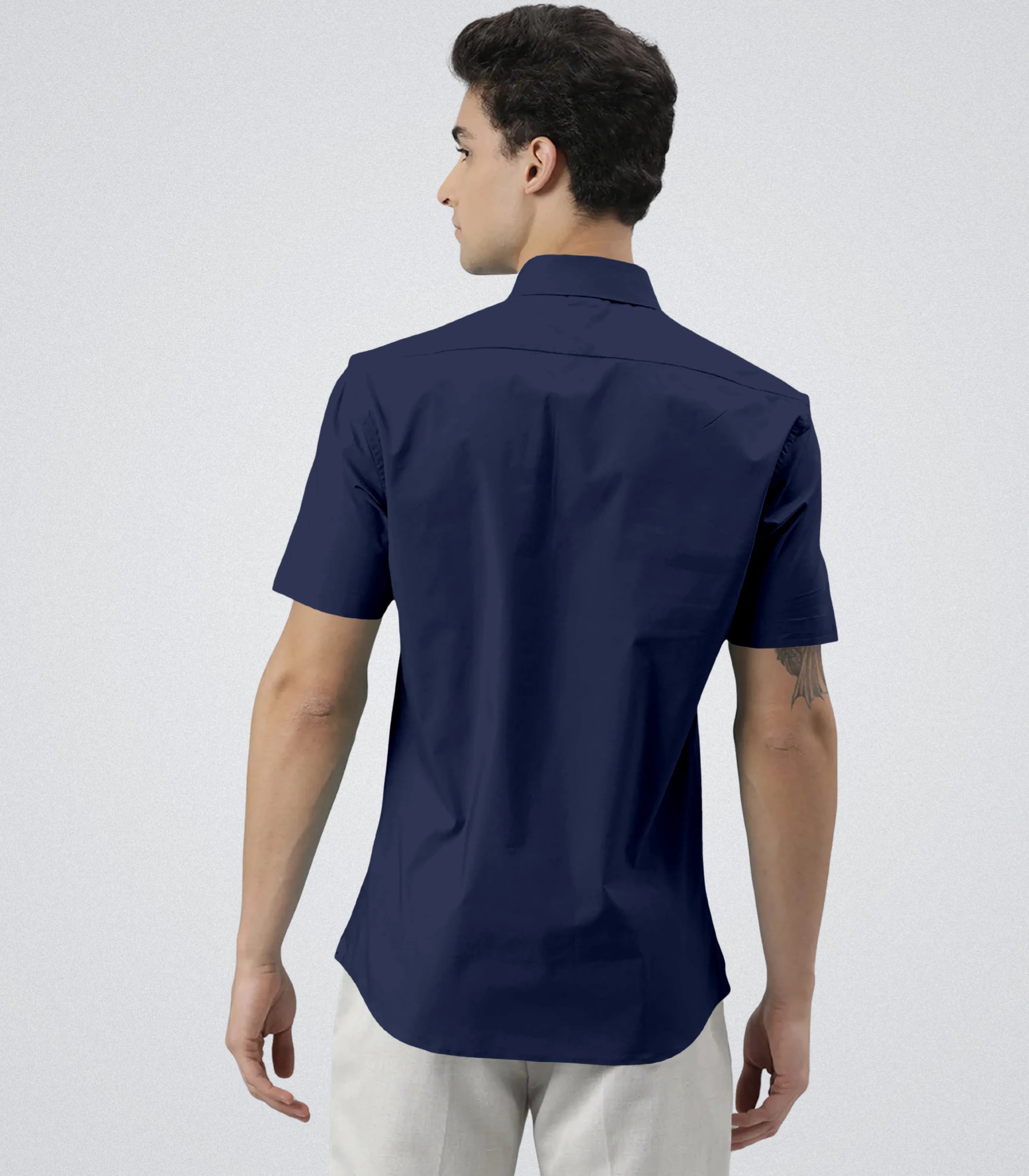 Man wearing a navy blue short-sleeve shirt on a white background
