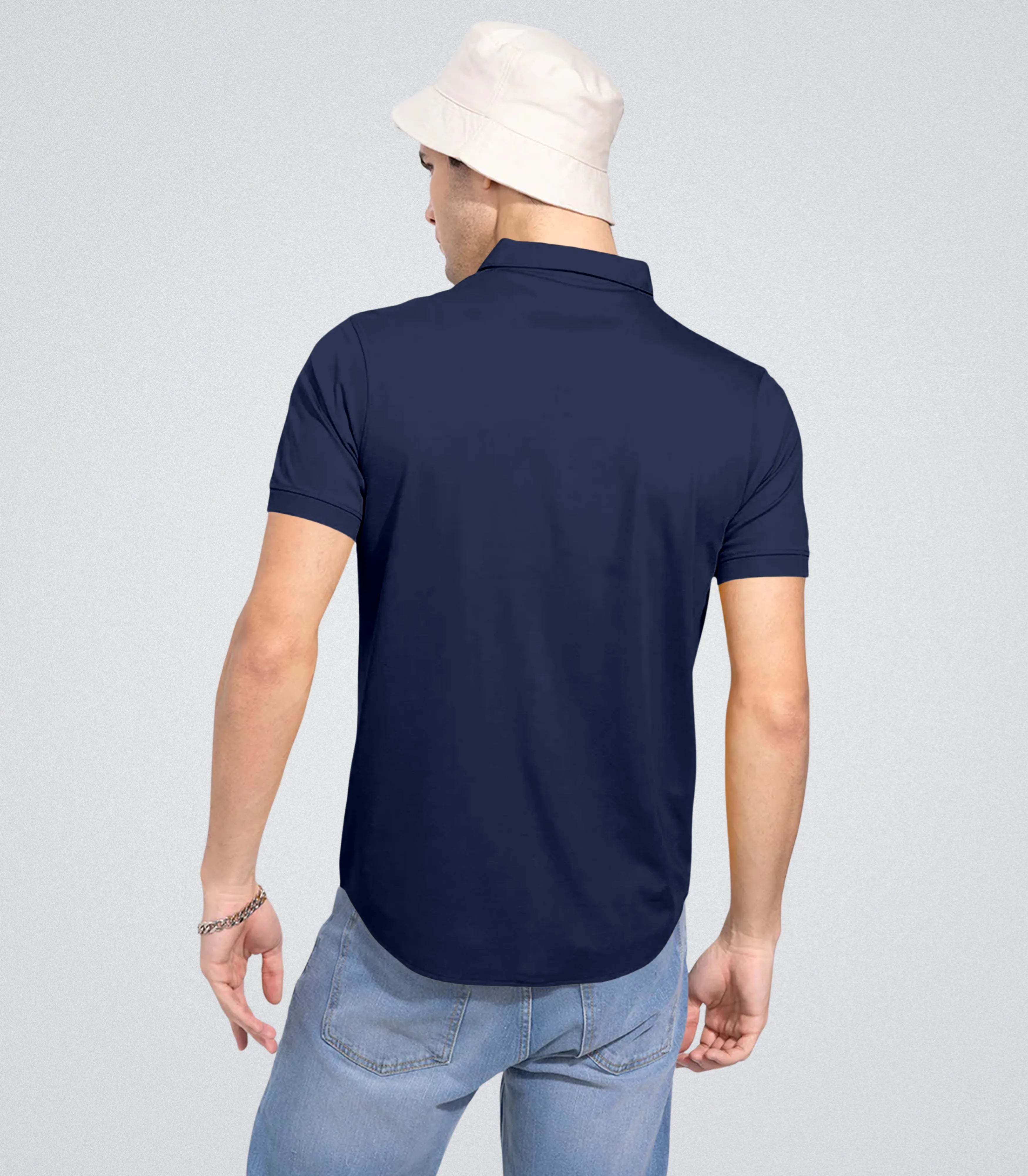 Person wearing a navy blue polo shirt on a light gray background