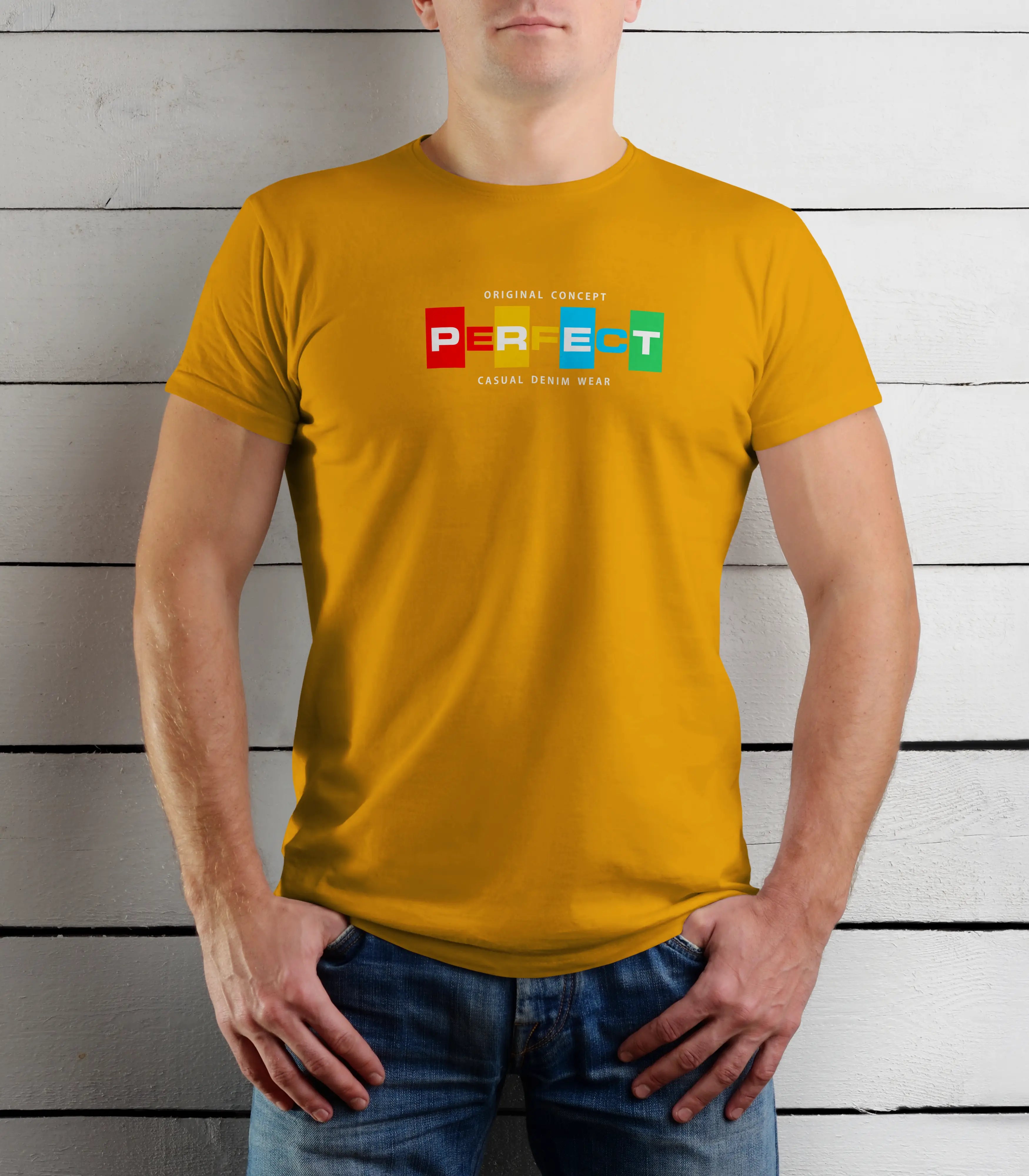 Person wearing a mustard yellow t-shirt with colorful text design against a wooden background