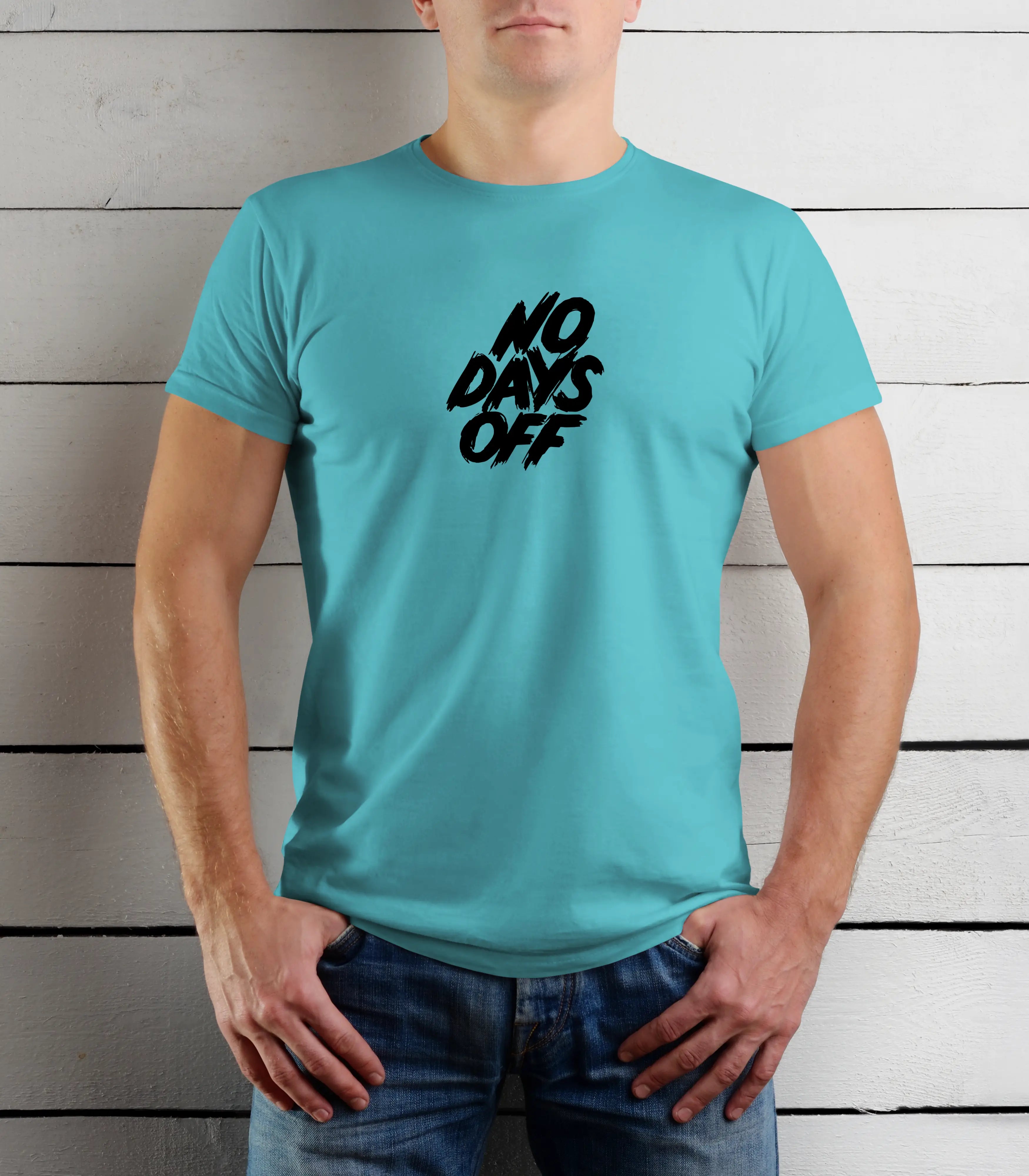 Person wearing a turquoise t-shirt with 'NO DAYS OFF' text against a wooden background