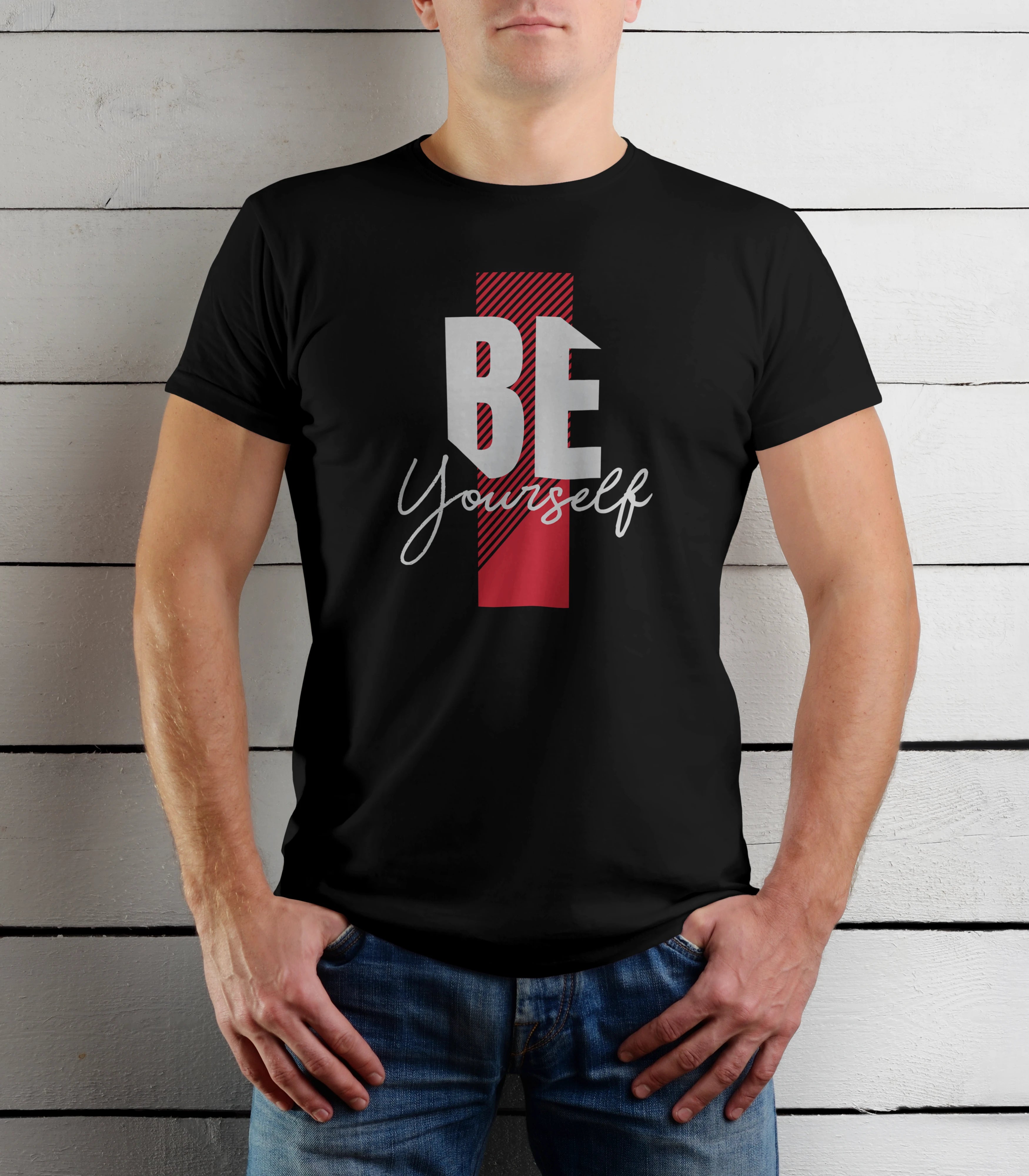 Person wearing a black t-shirt with 'BE Yourself' text design against a wooden background