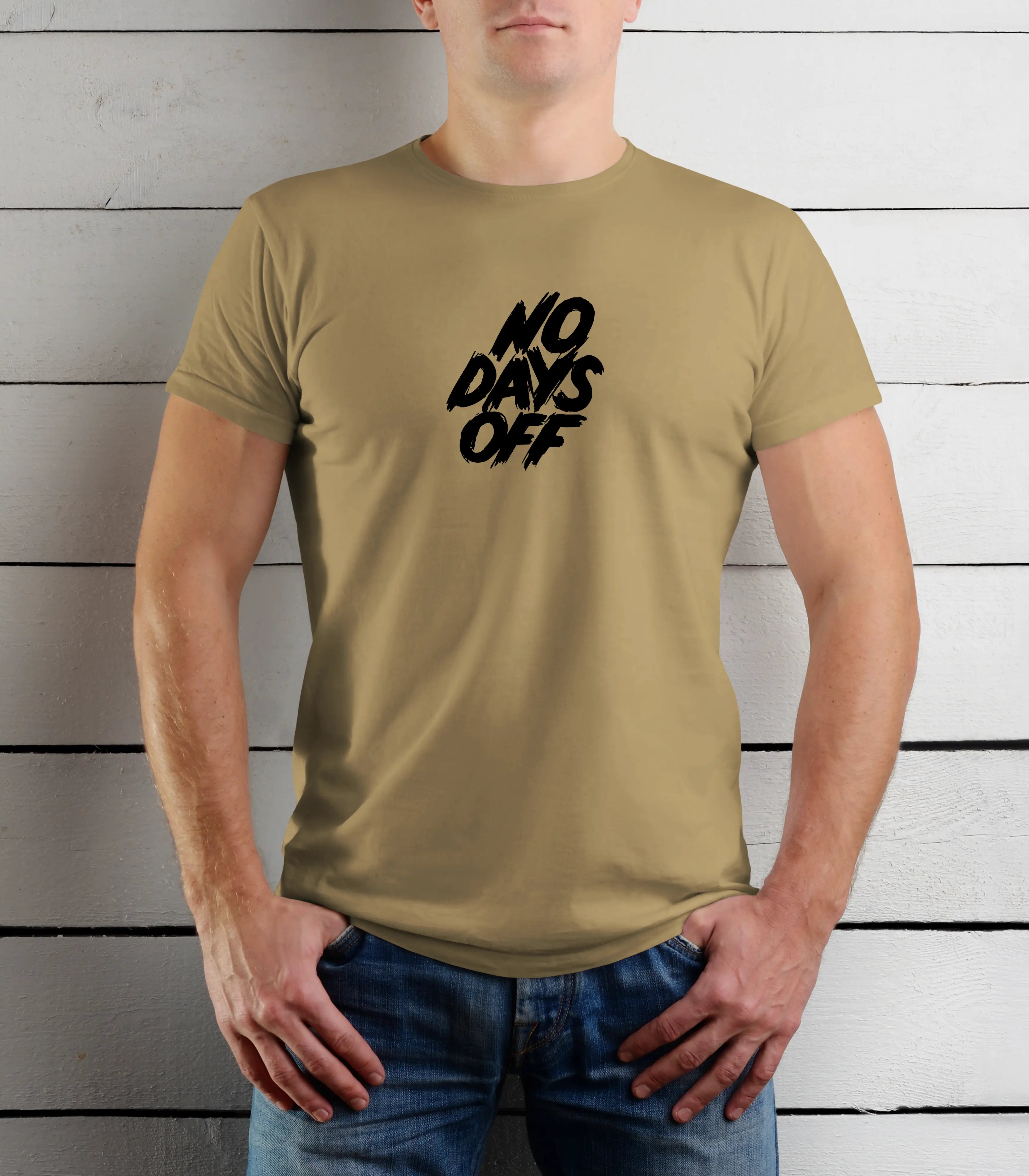 Person wearing a beige t-shirt with 'NO DAYS OFF' text against a wooden background