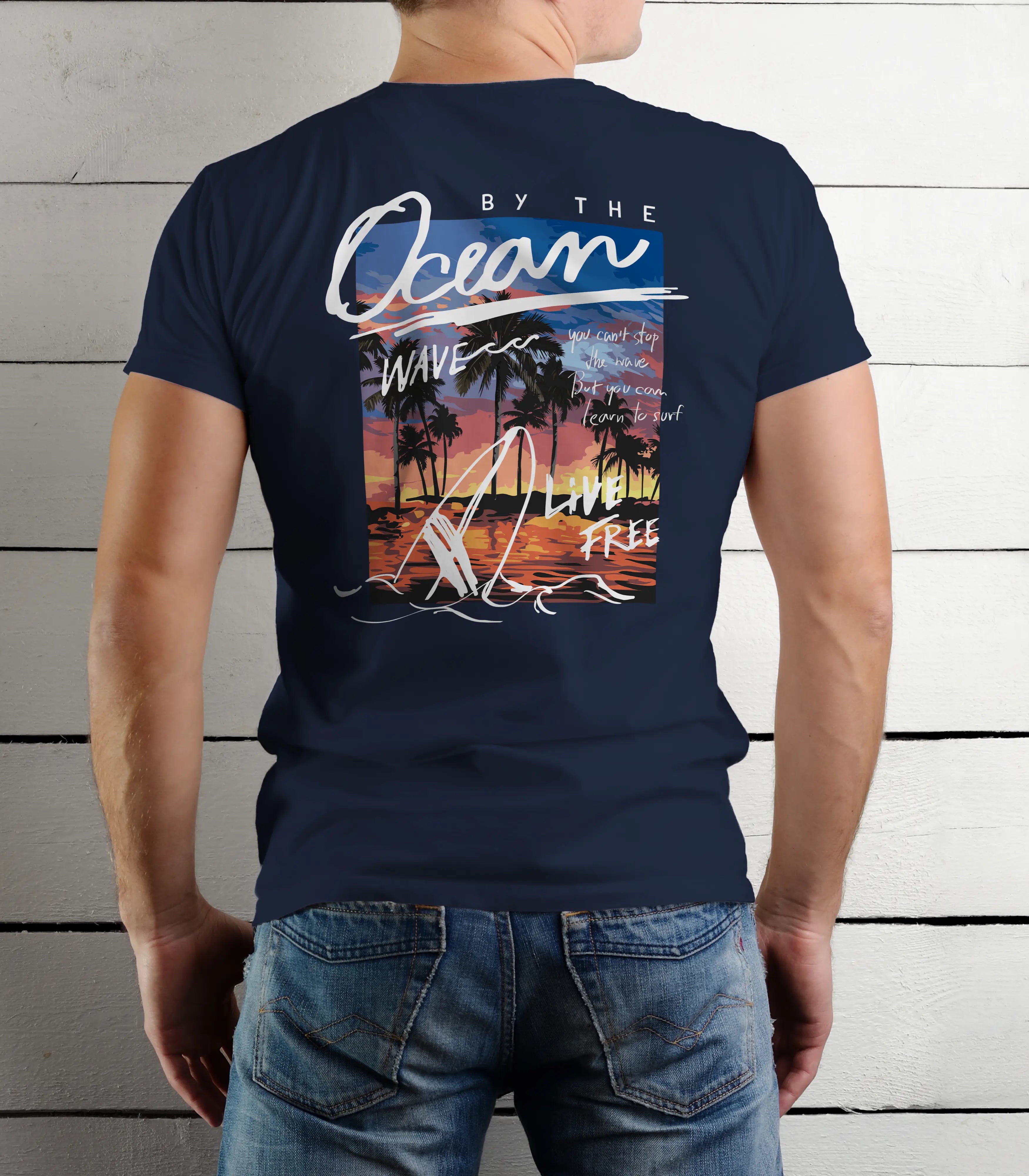 Navy blue t-shirt with a beach-themed design on the back, worn by a person against a wooden panel background.