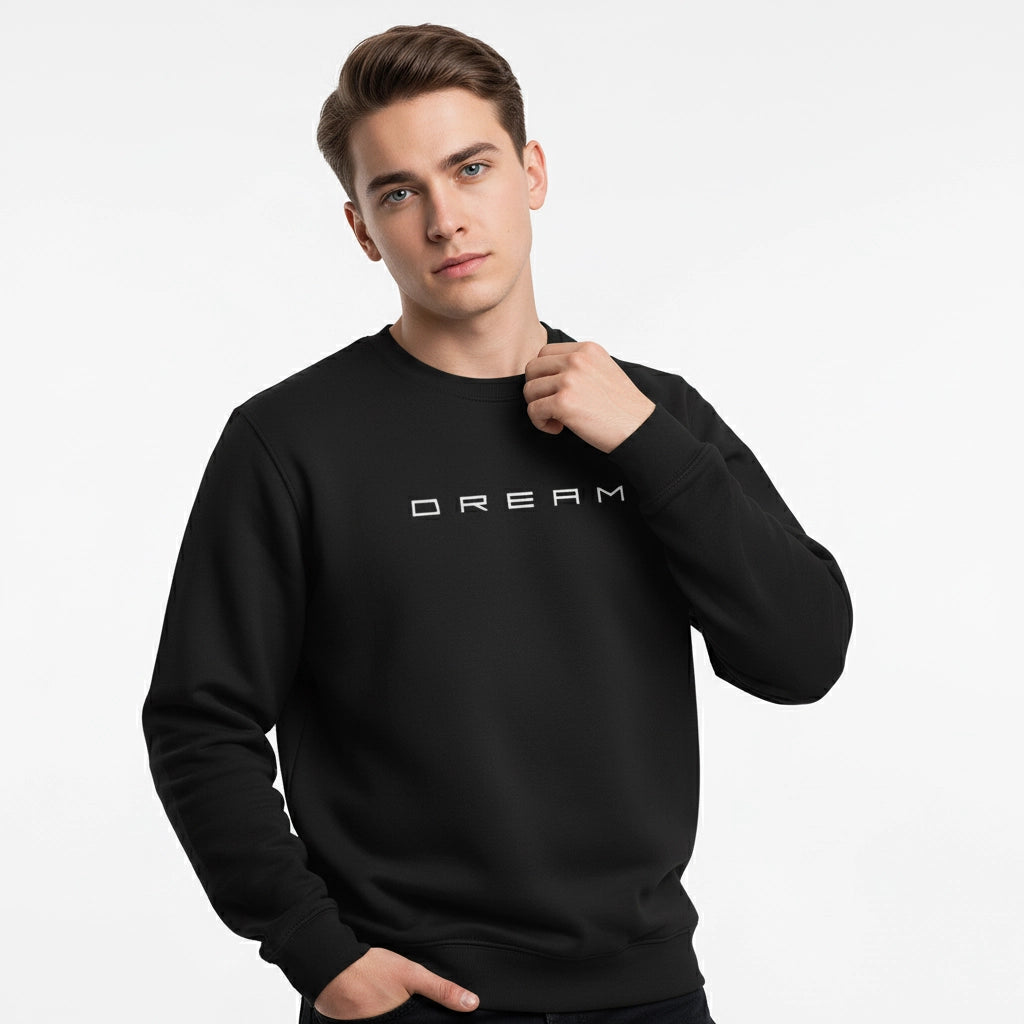 Person wearing a black sweatshirt with 'DREAM' printed on it against a light gray background