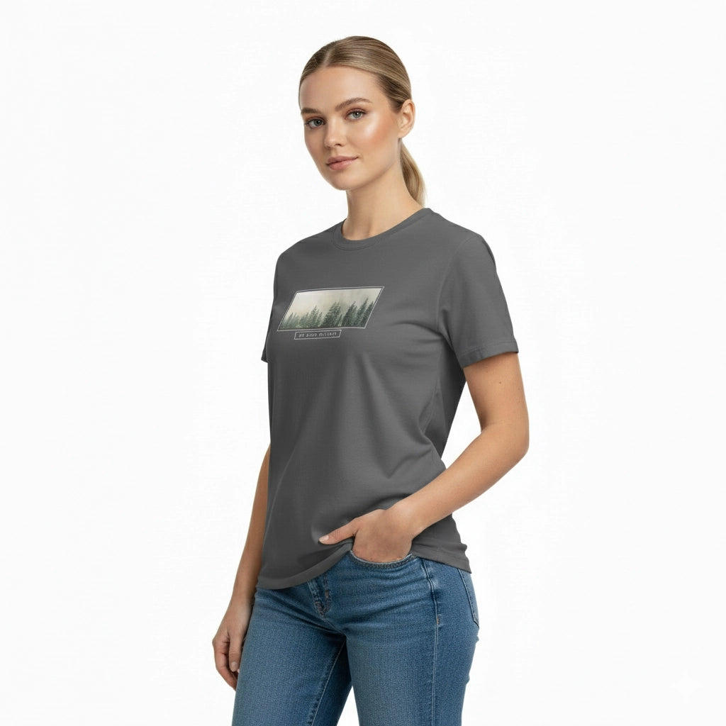 Woman wearing a gray t-shirt with a forest graphic on a white background