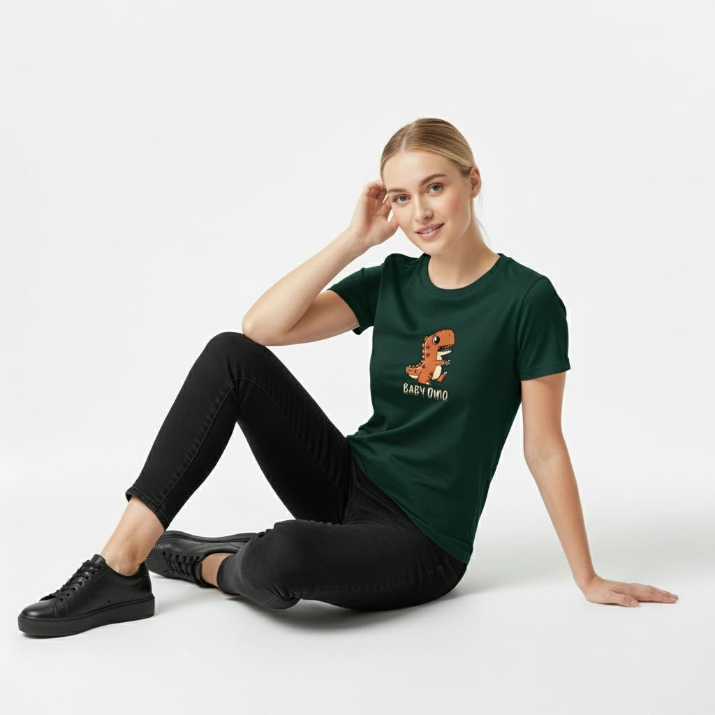 Woman wearing a green t-shirt with a dinosaur graphic and text, sitting on the floor against a white background.