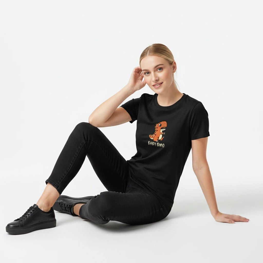 Woman wearing a black t-shirt with a dinosaur graphic and text, sitting on a white background