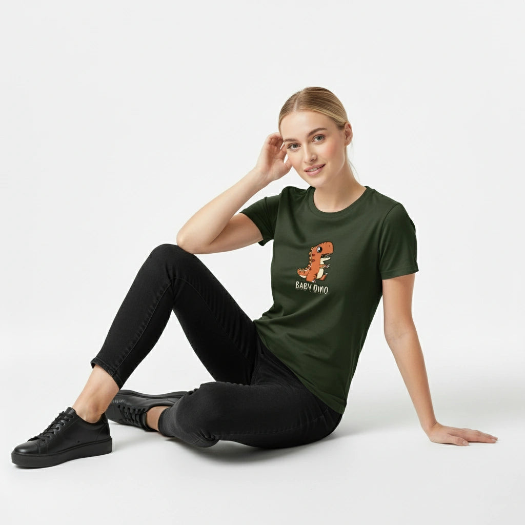 Woman wearing a green t-shirt with a dinosaur graphic and text, sitting on the floor against a white background.
