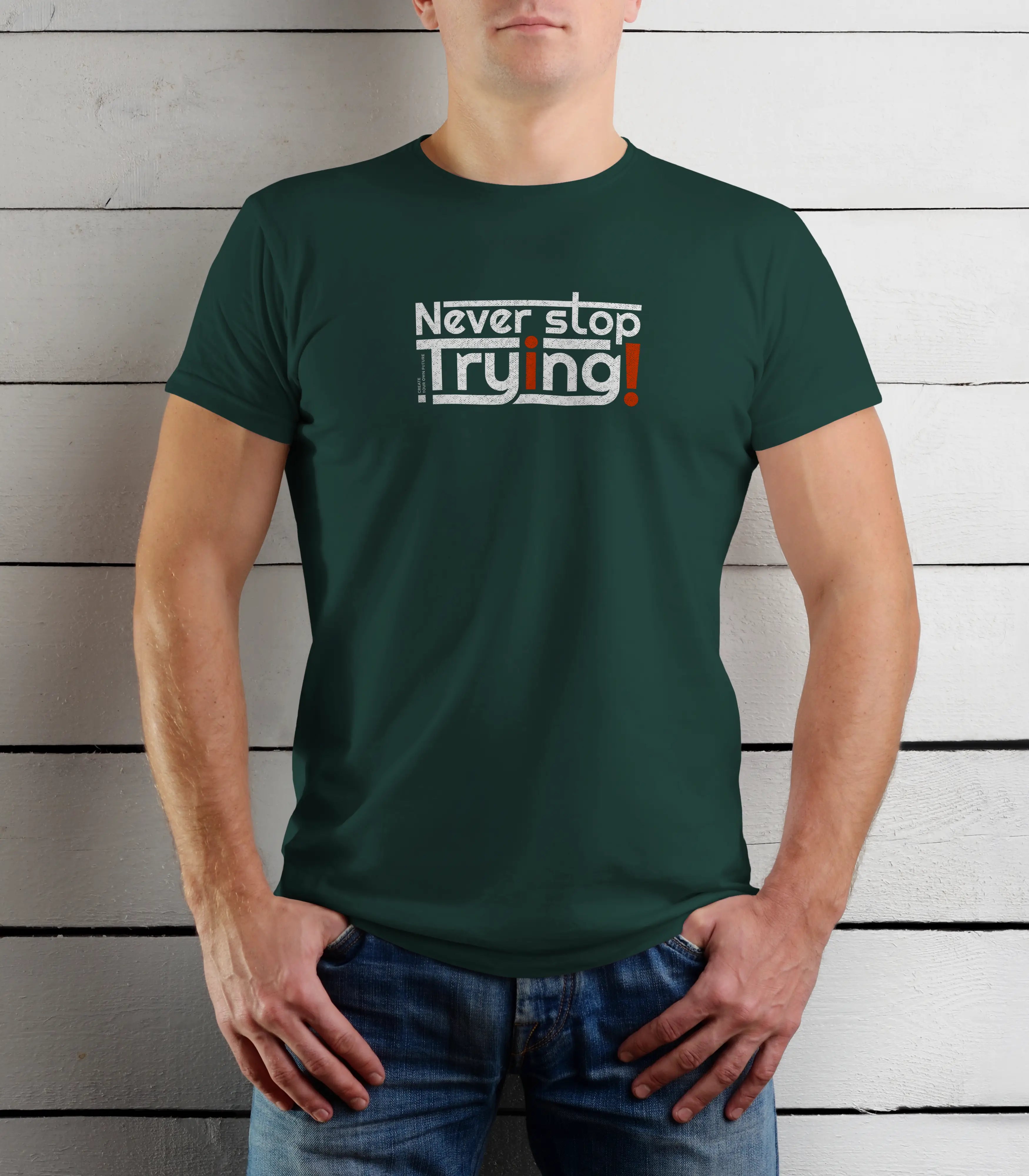 Person wearing a green t-shirt with 'Never stop Trying' text against a wooden background