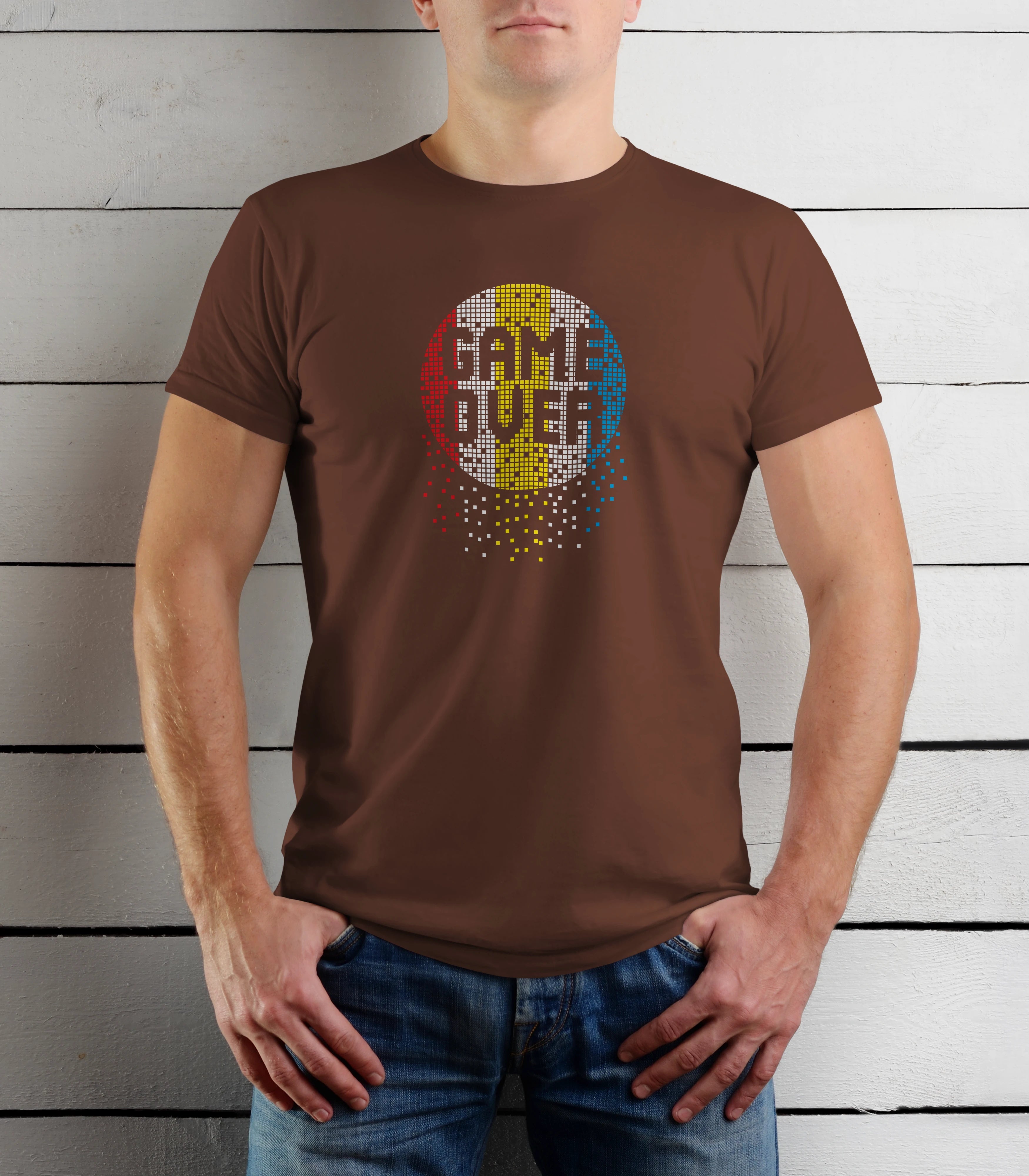 Person wearing a brown t-shirt with a colorful graphic design on a wooden background