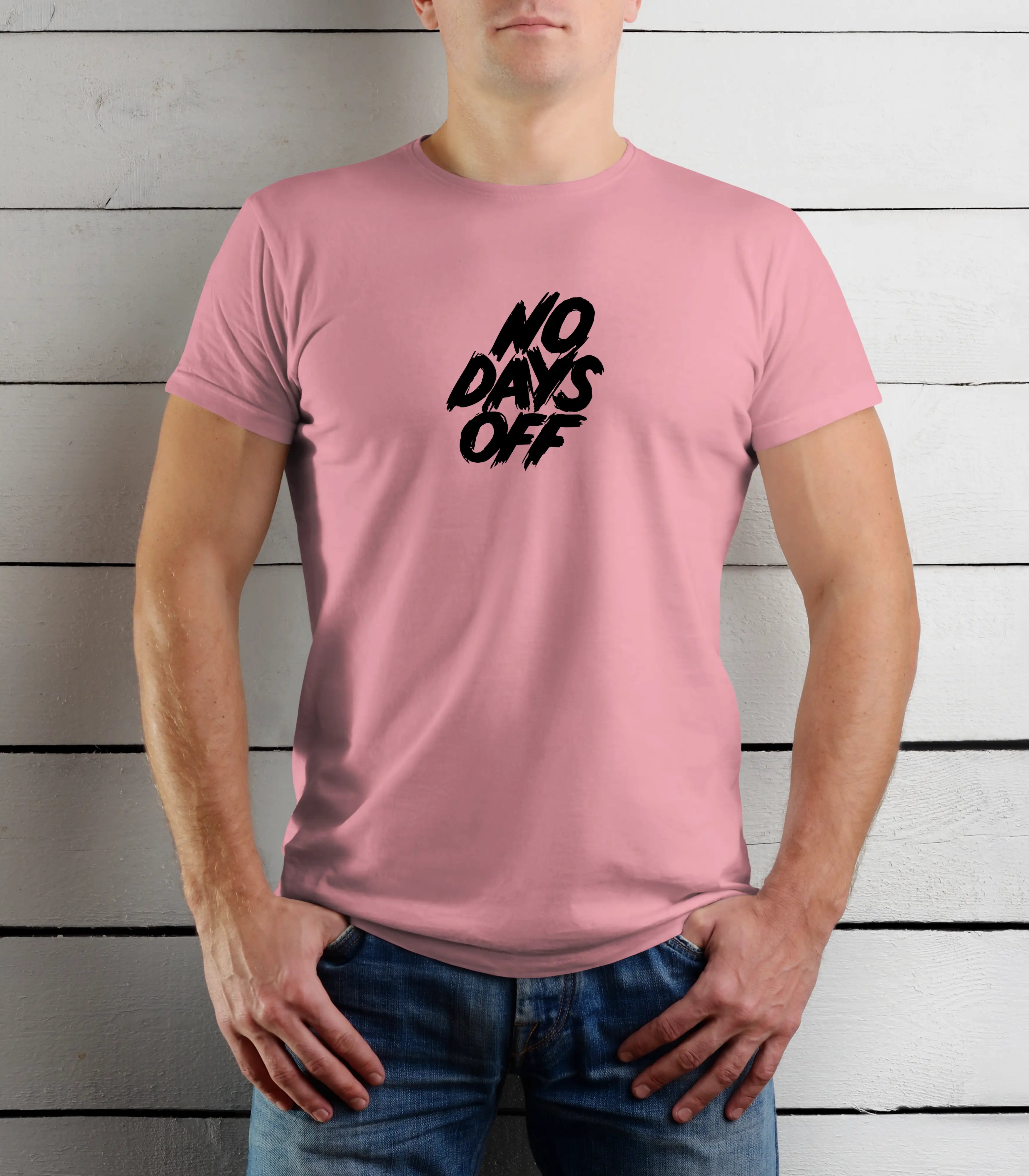 Person wearing a pink t-shirt with 'NO DAYS OFF' text against a wooden background