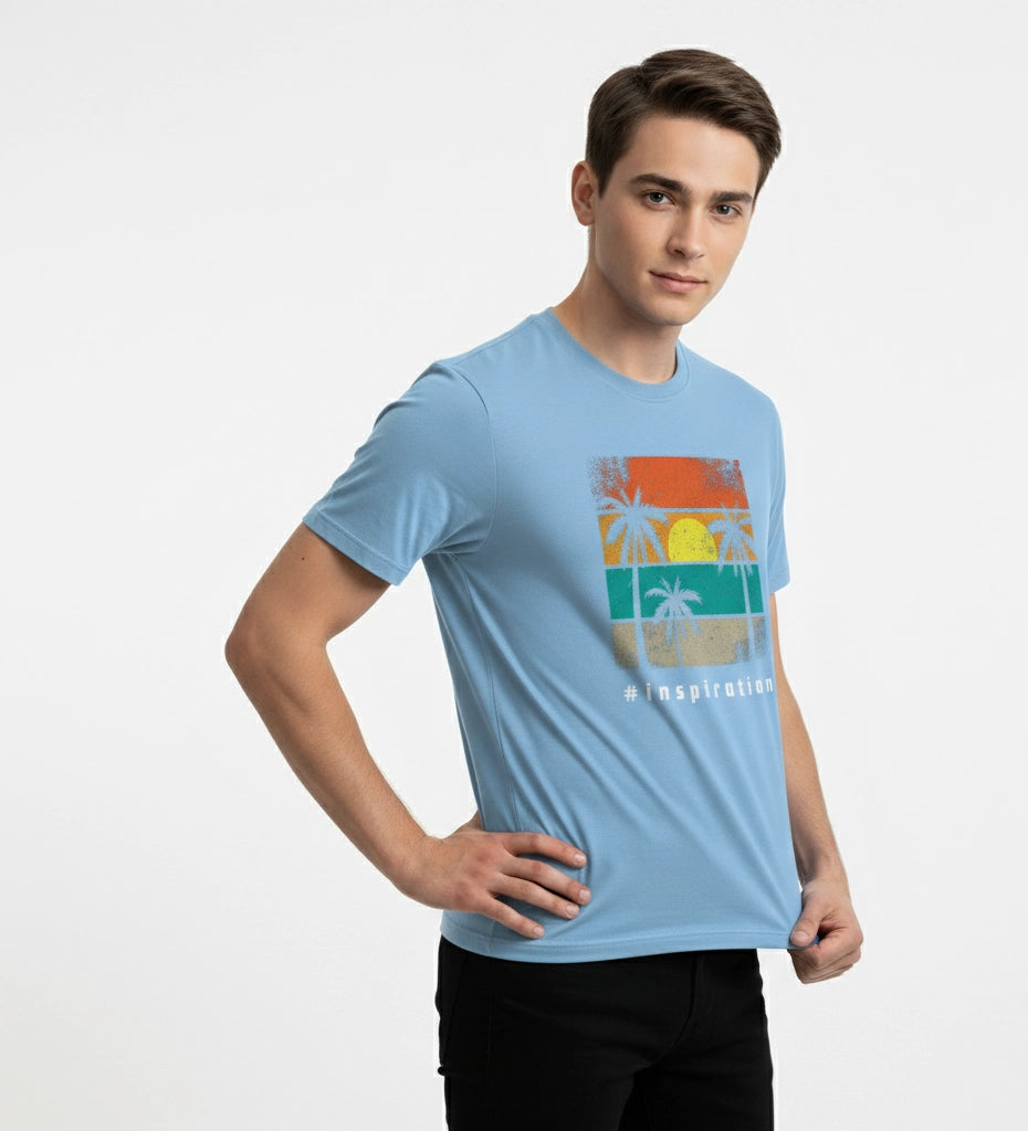Man wearing a light blue t-shirt with a colorful graphic design on a white background