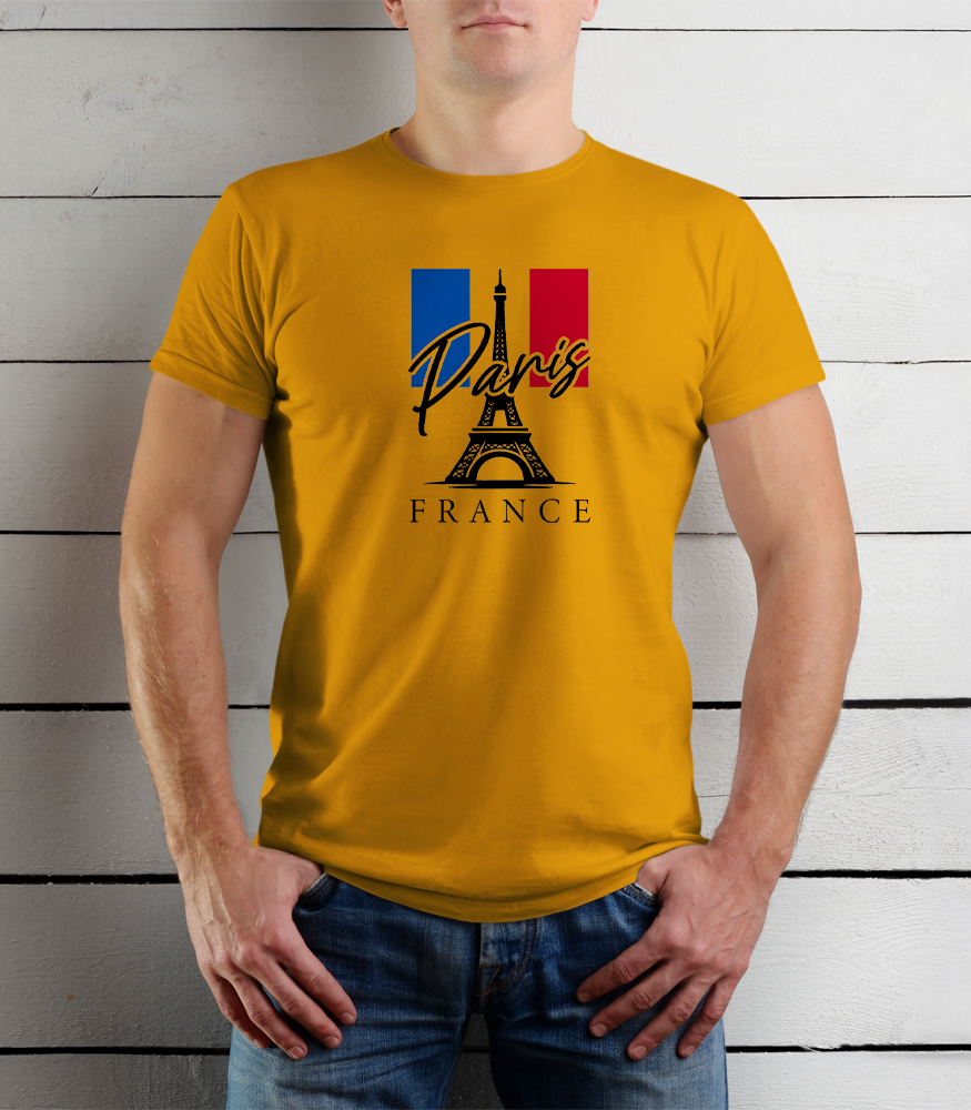 Person wearing a yellow t-shirt with Paris and France design against a wooden background