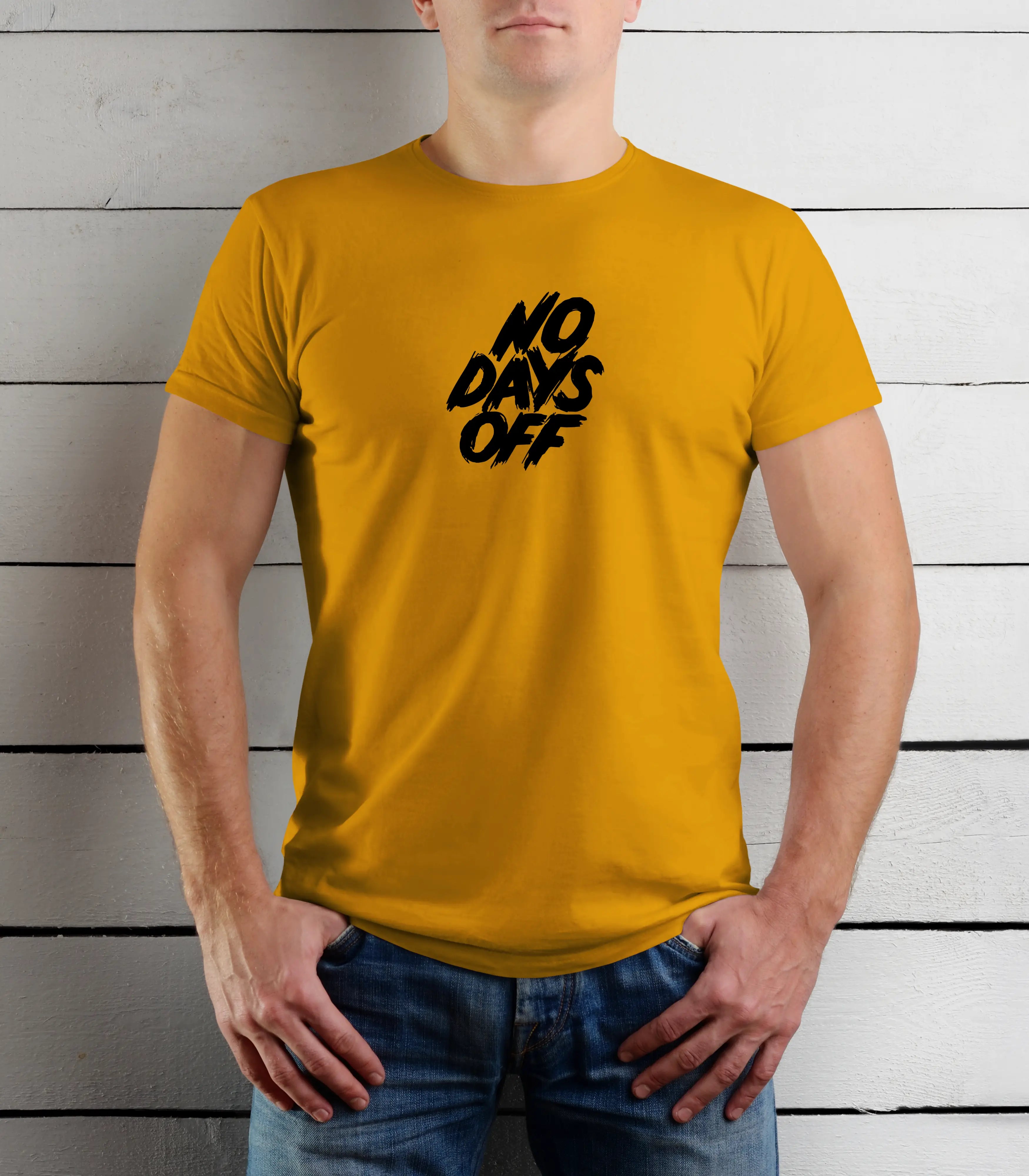 Person wearing a yellow t-shirt with 'NO DAYS OFF' text against a wooden background