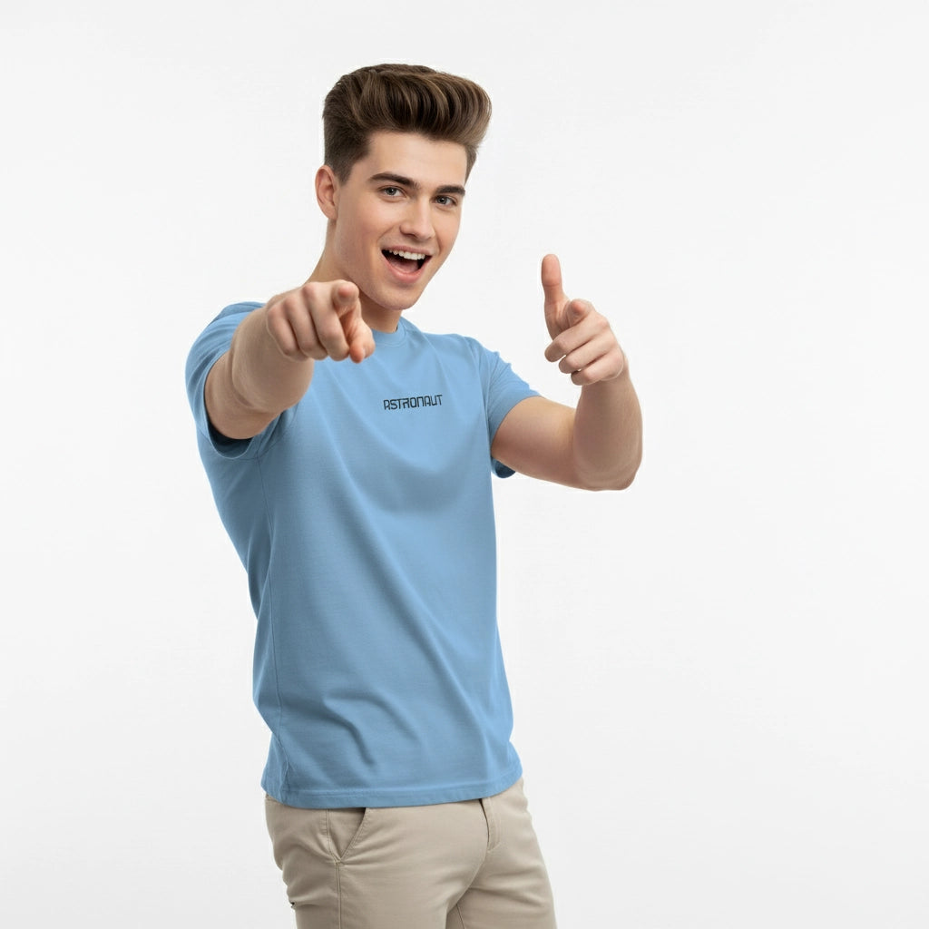 Man wearing a light blue t-shirt with a brand logo, pointing forward on a white background