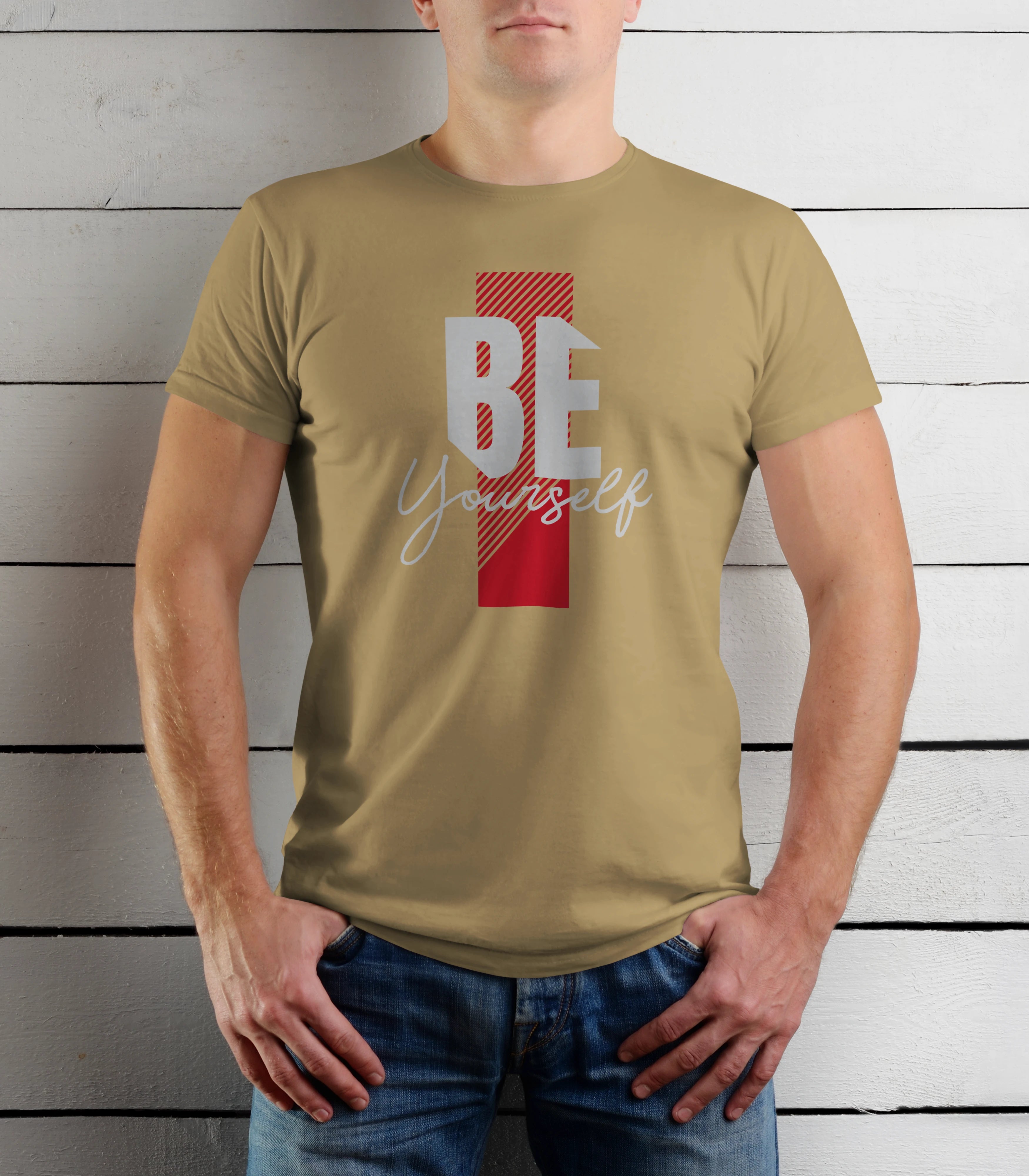 Person wearing a khaki t-shirt with 'BE yourself' text design against a wooden background