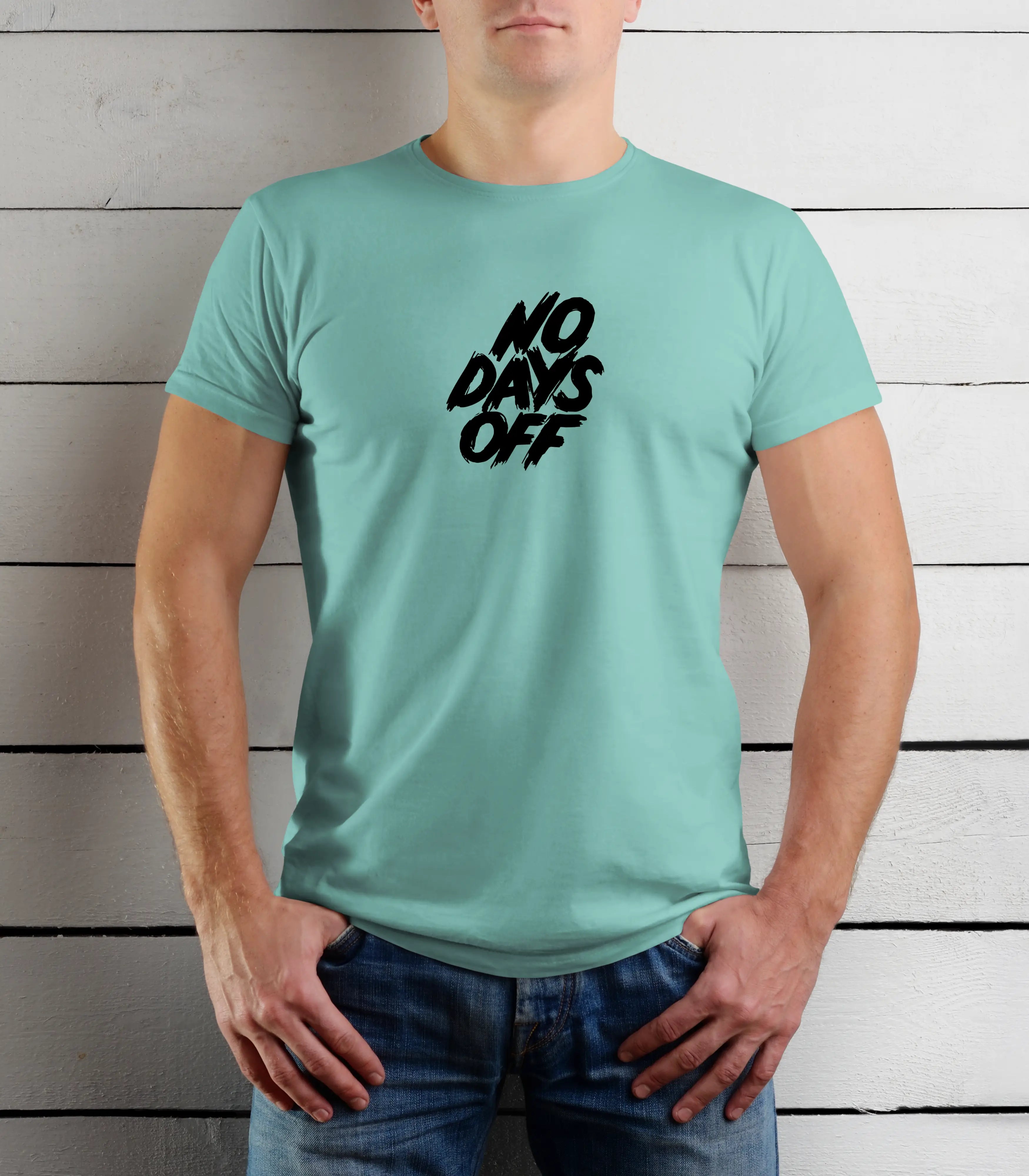 Person wearing a light blue t-shirt with 'NO DAYS OFF' text against a wooden background