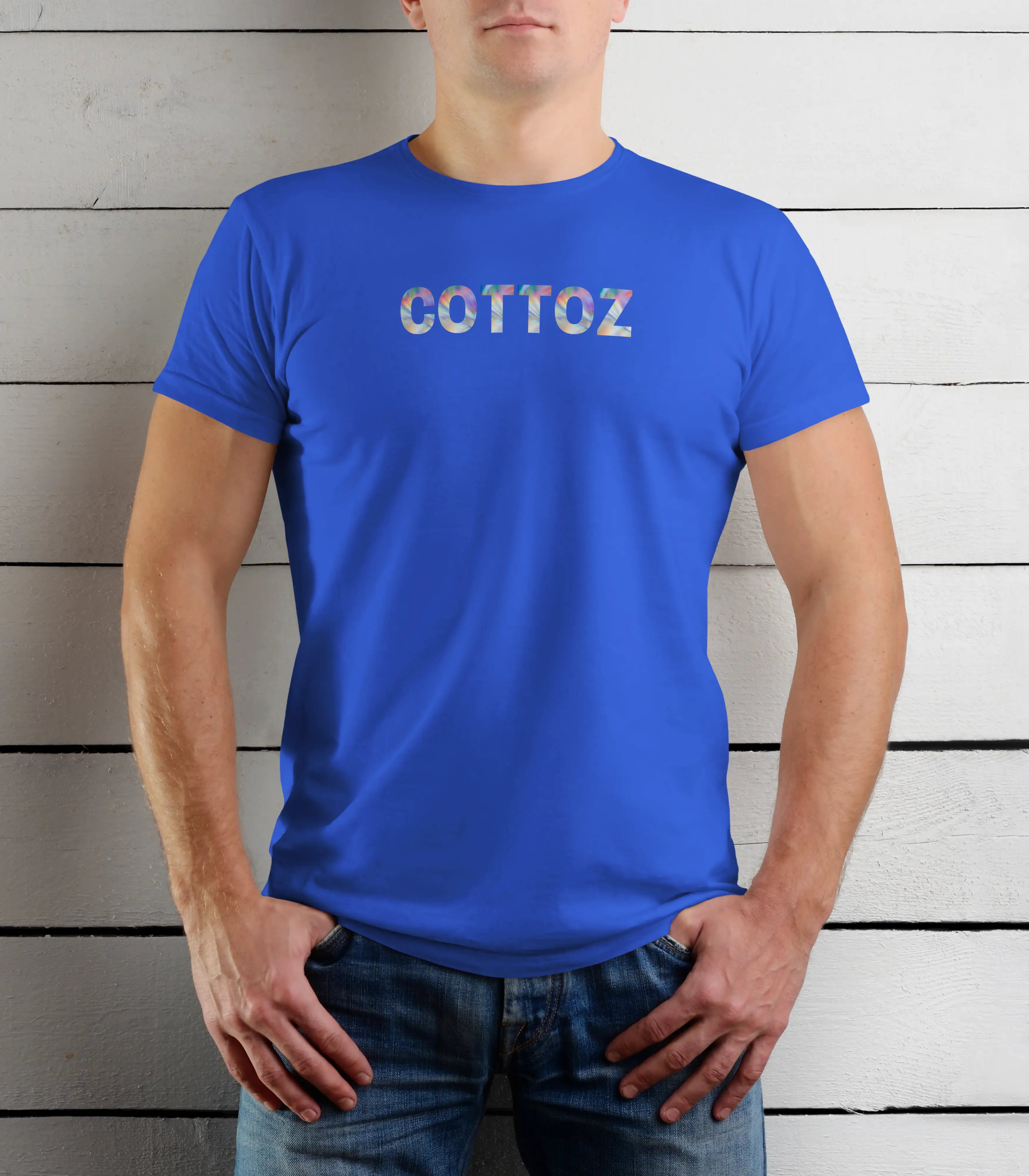 Person wearing a blue t-shirt with 'COTTOZ' printed on it against a wooden background