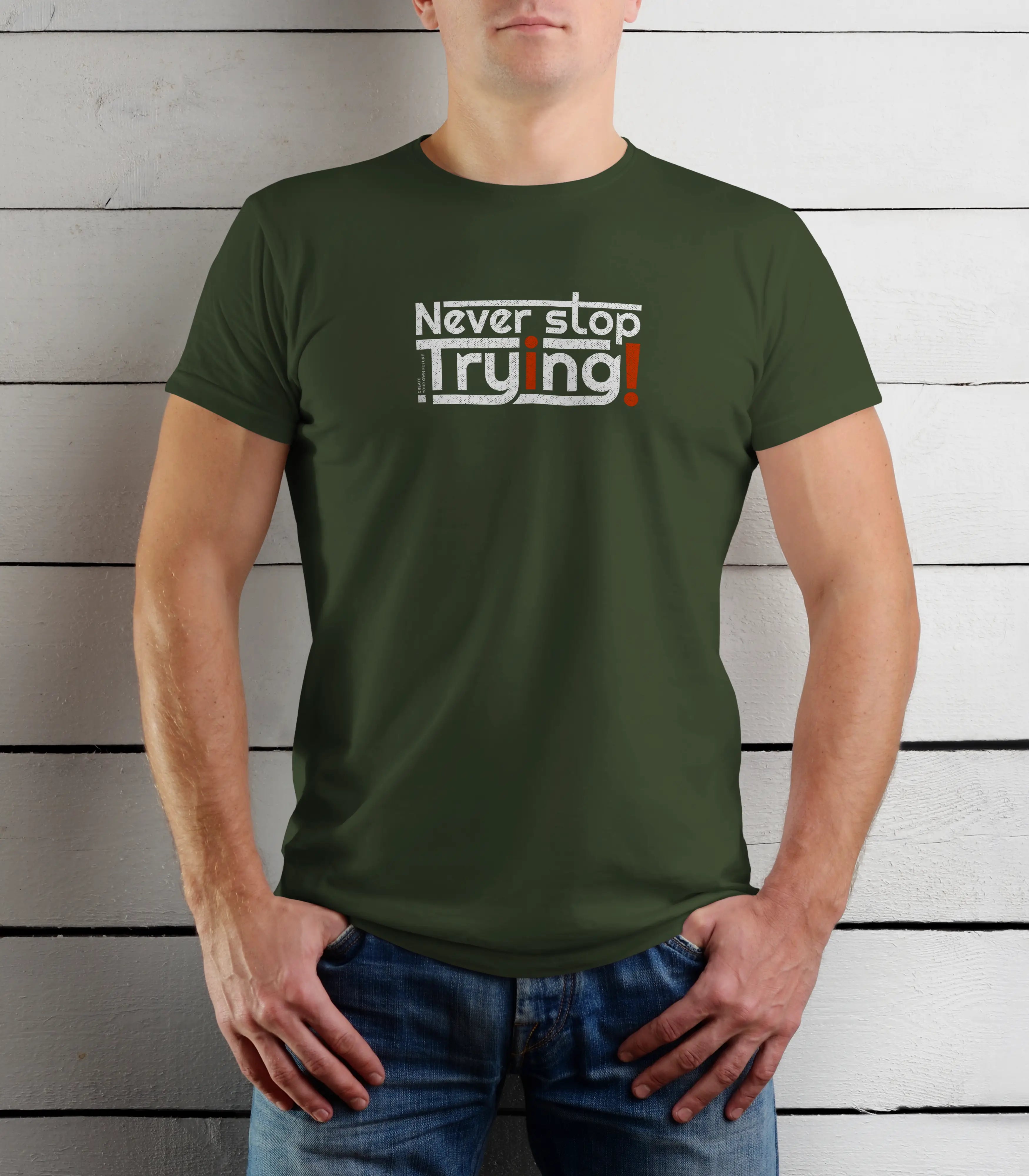 Person wearing a green t-shirt with motivational text against a wooden background