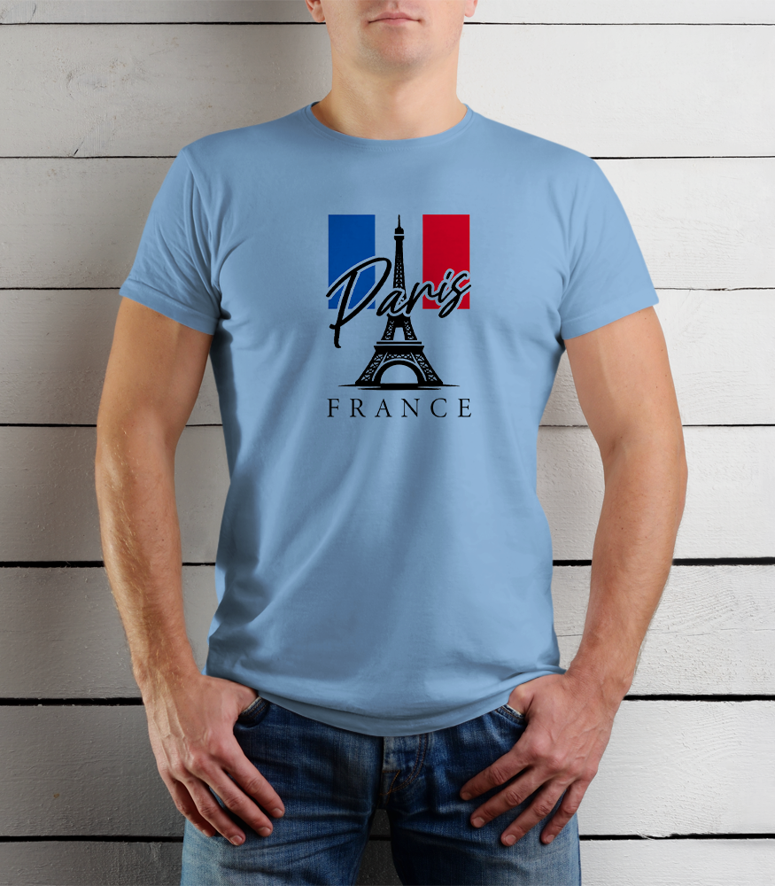Person wearing a light blue t-shirt with Paris and France design against a wooden background