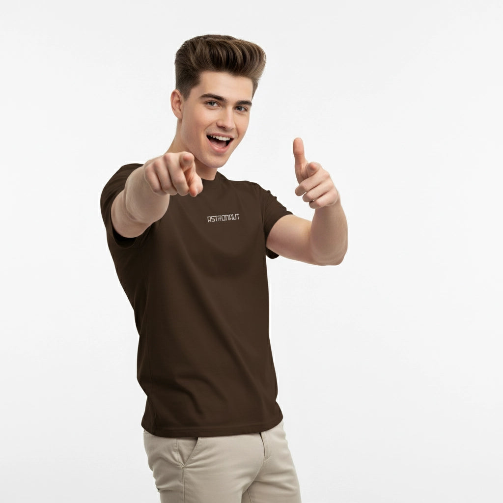 Man wearing a brown t-shirt with text, pointing forward on a white background
