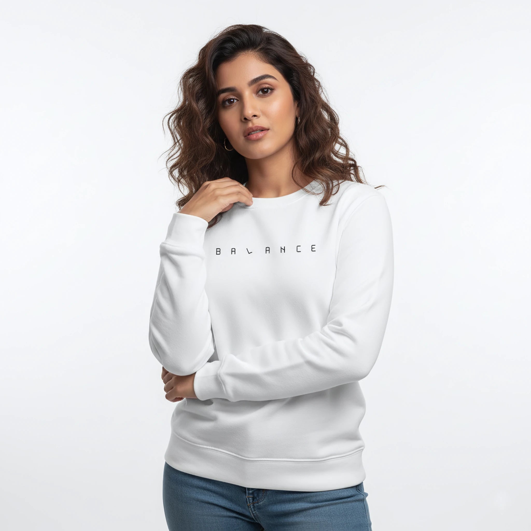 Woman wearing a white sweatshirt with 'BALANCE' text on a plain background