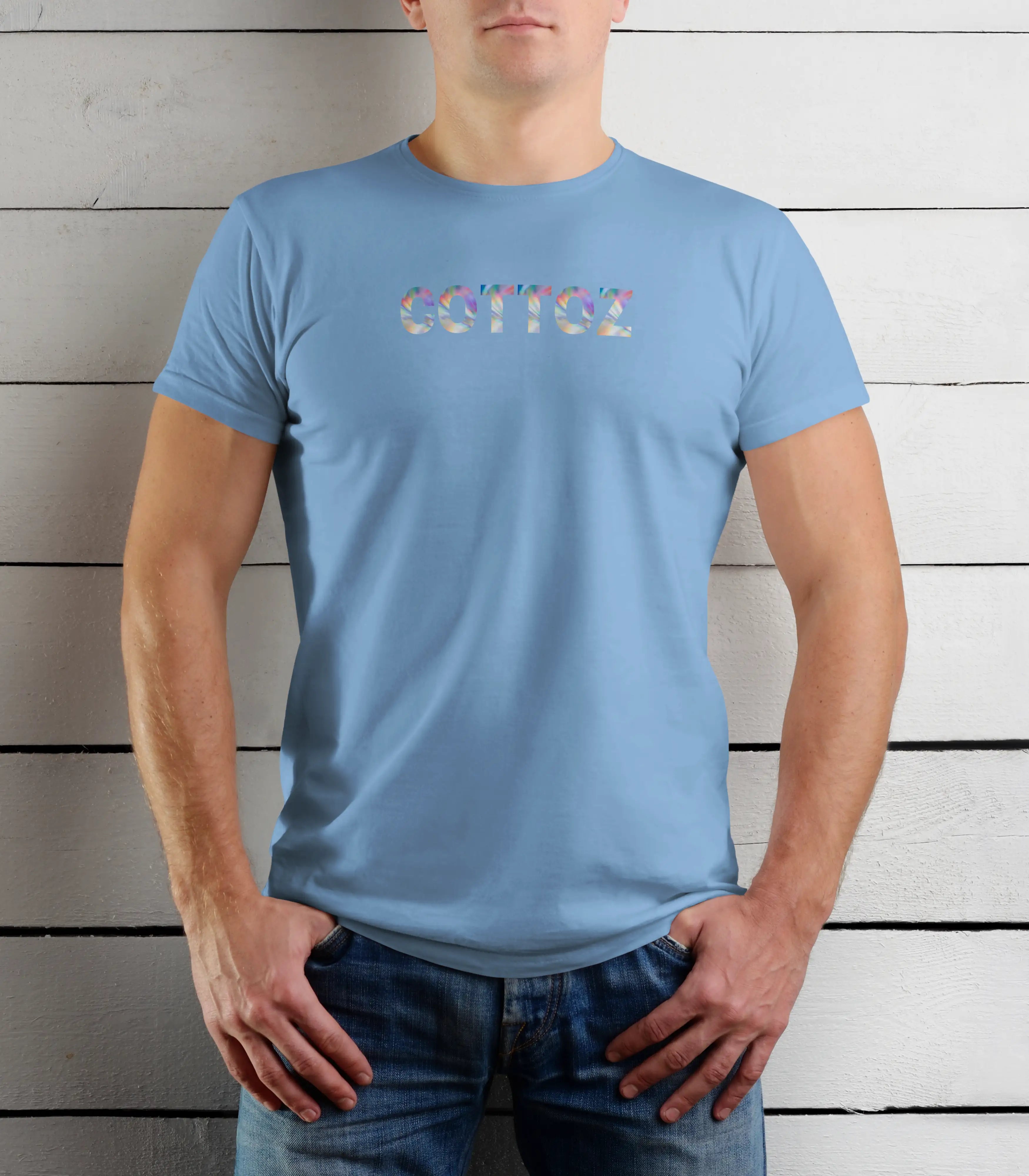 Person wearing a light blue t-shirt with colorful text against a wooden background