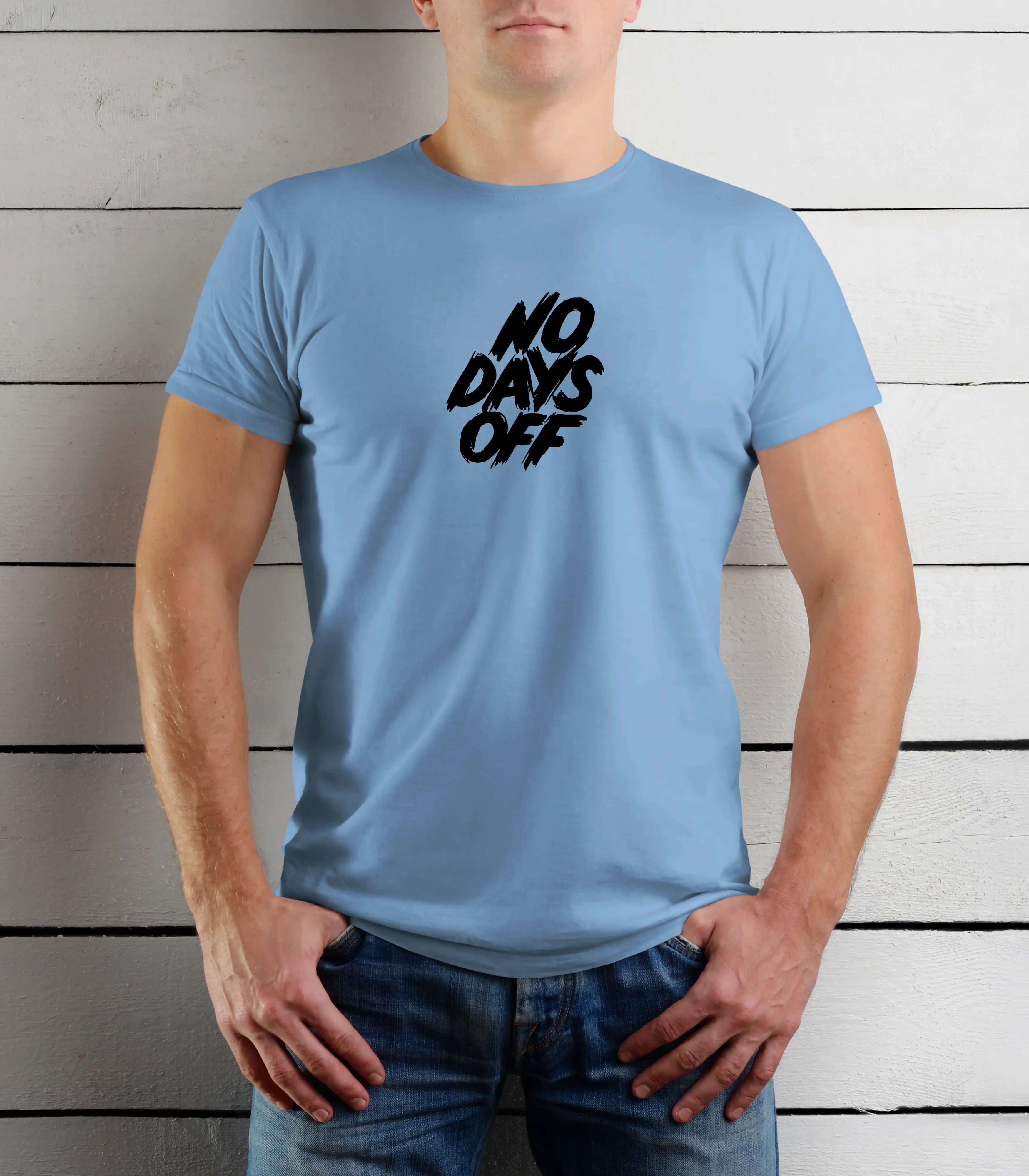 Person wearing a light blue t-shirt with 'NO DAYS OFF' text against a wooden background