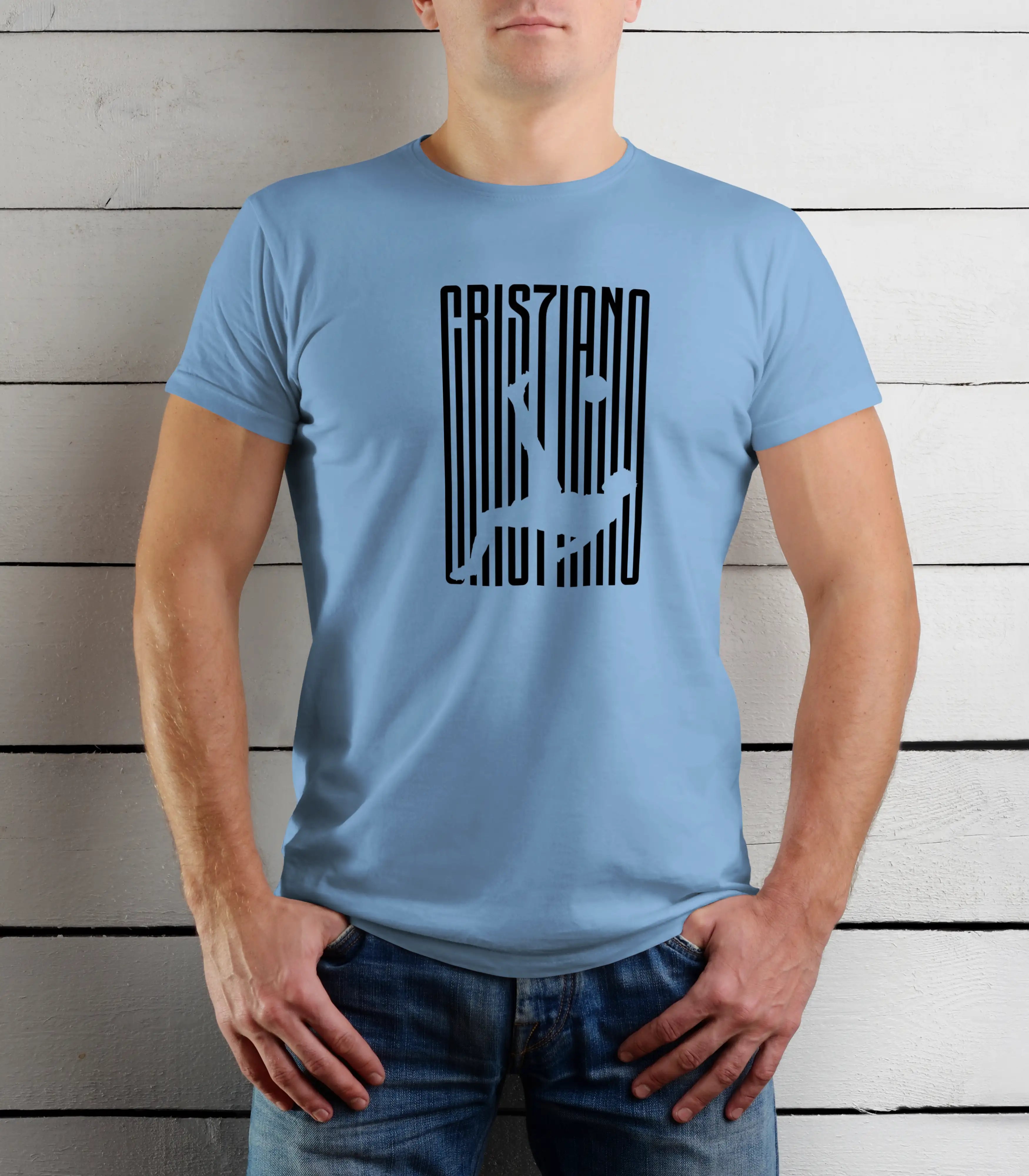 Person wearing a light blue t-shirt with a black graphic design against a wooden background