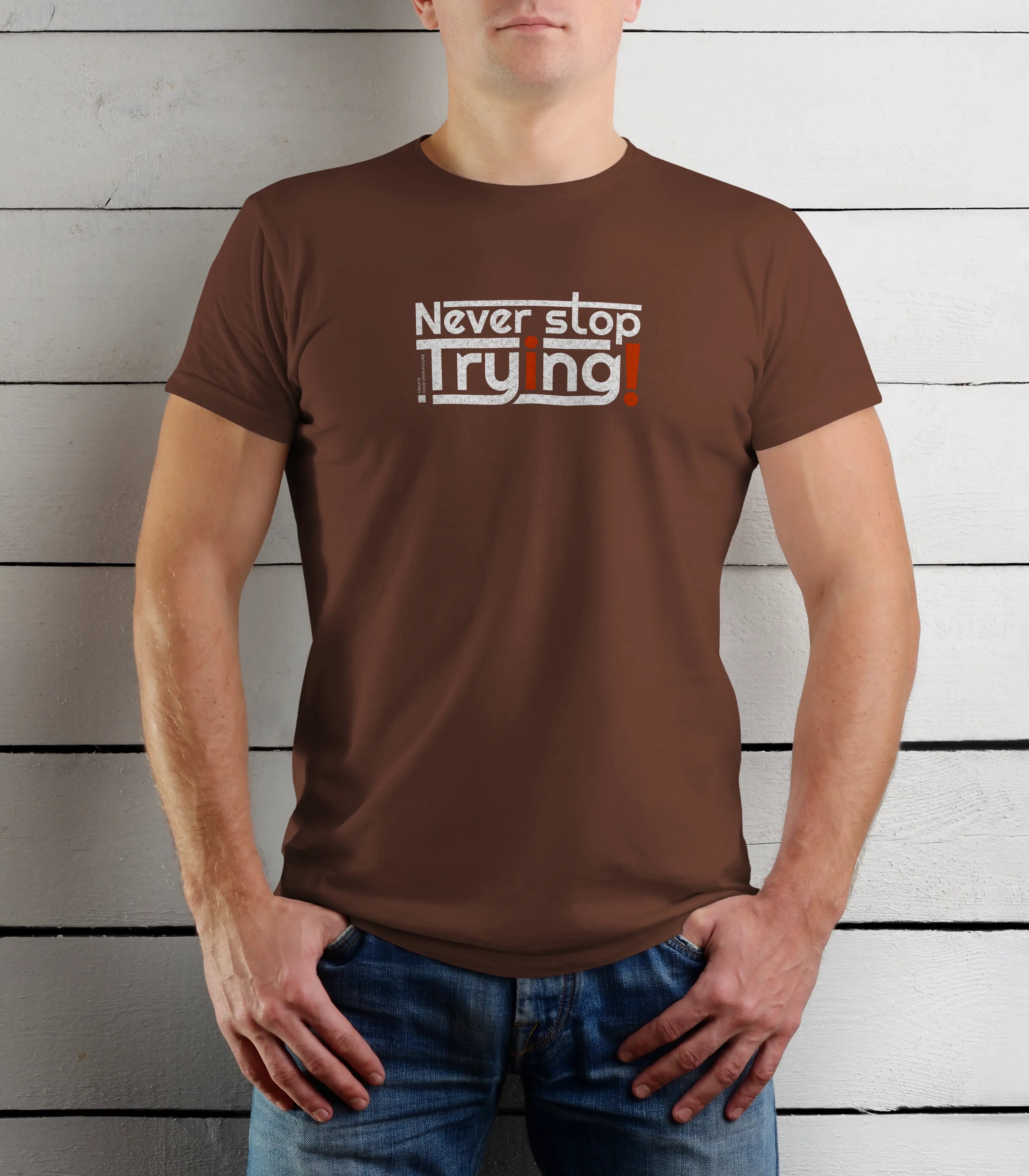 Person wearing a brown t-shirt with 'Never stop Trying' text against a wooden background