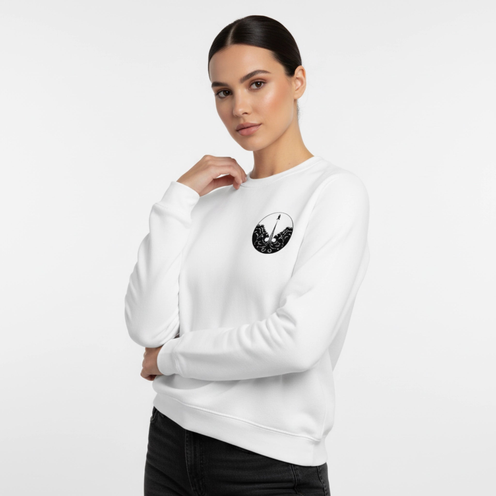 Woman wearing a white sweatshirt with a black graphic design on a light gray background