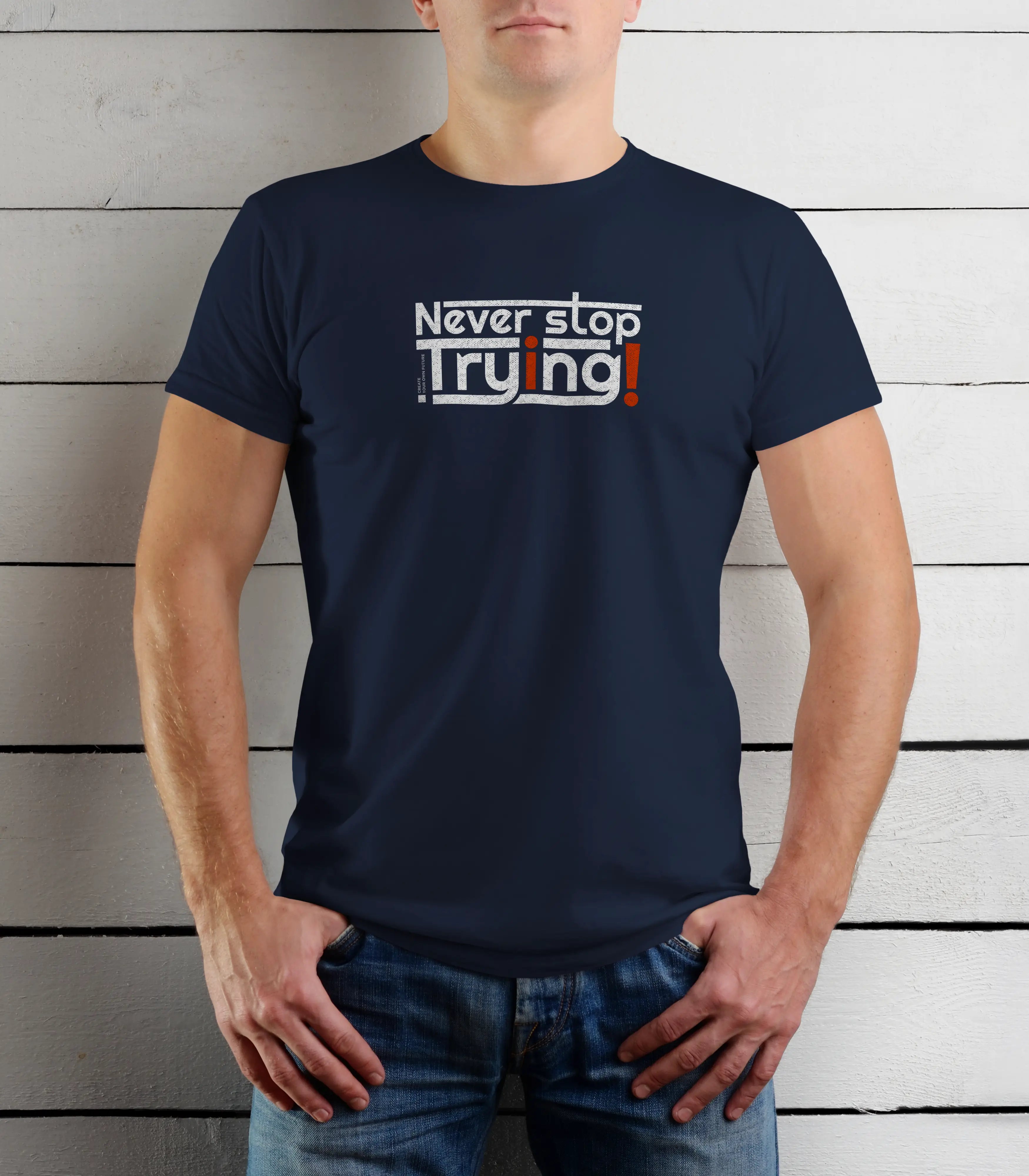 Person wearing a navy blue t-shirt with 'Never stop Trying' text against a wooden background