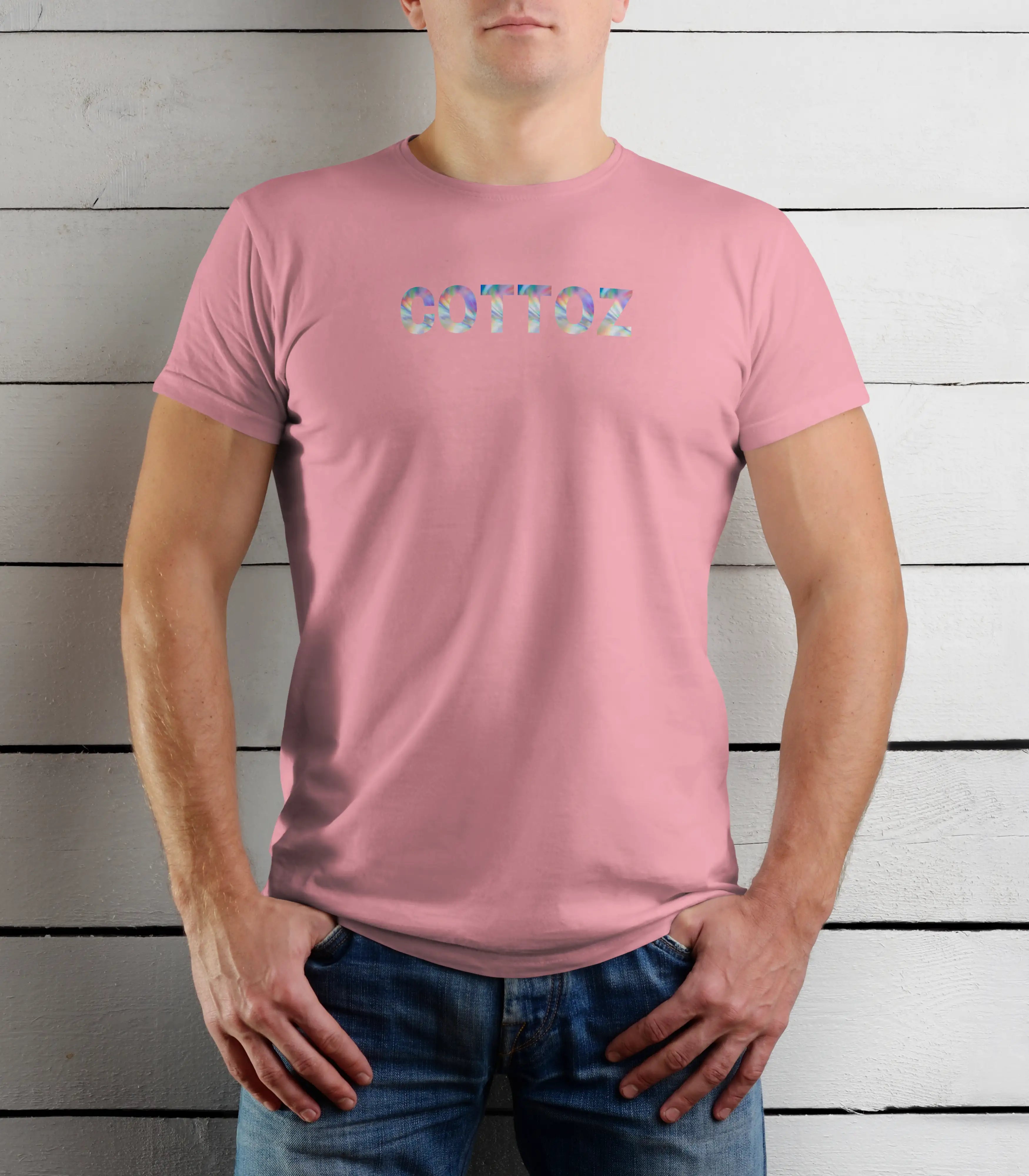 Person wearing a pink t-shirt with colorful text against a wooden background