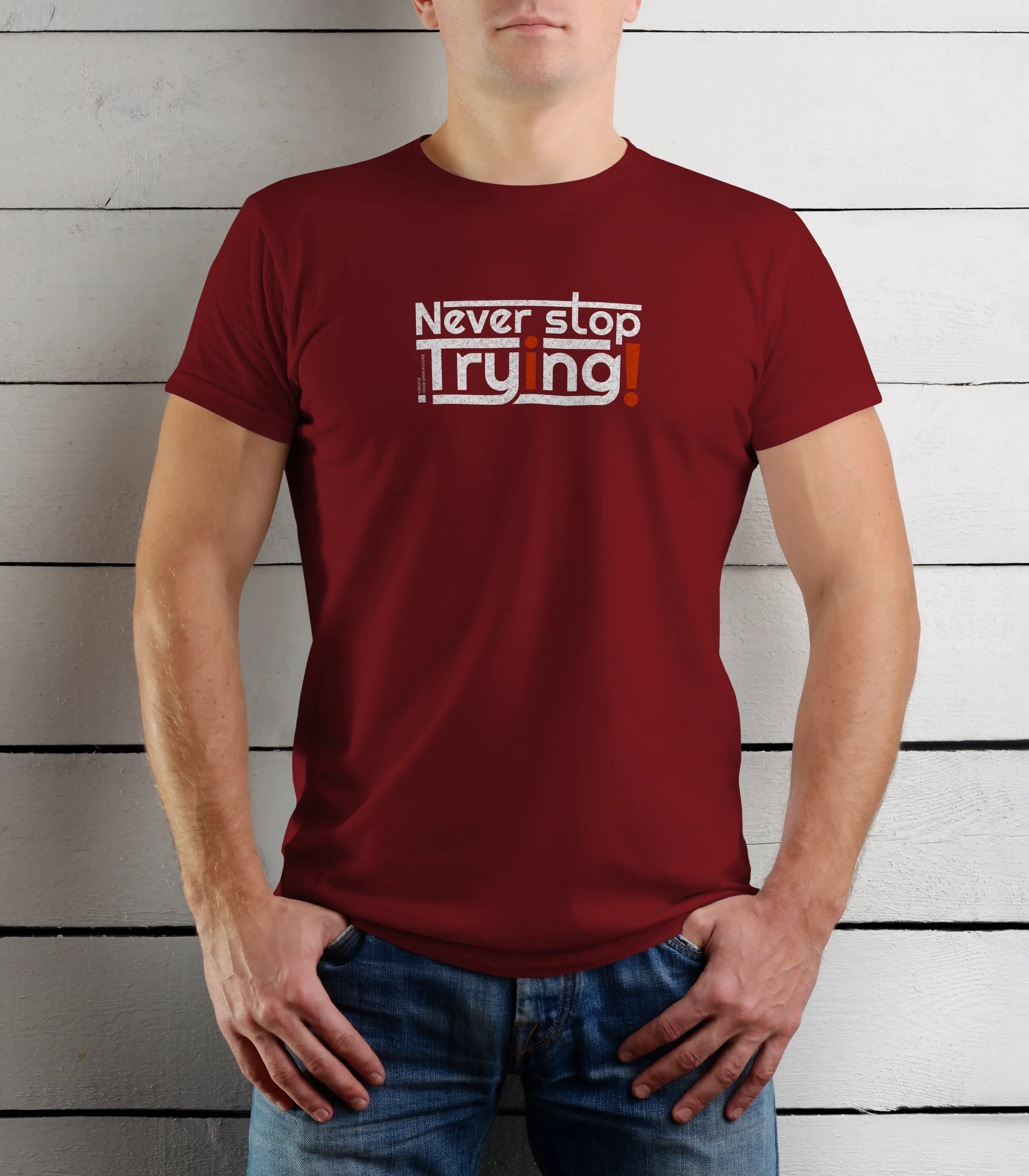 Person wearing a red t-shirt with motivational text against a wooden background