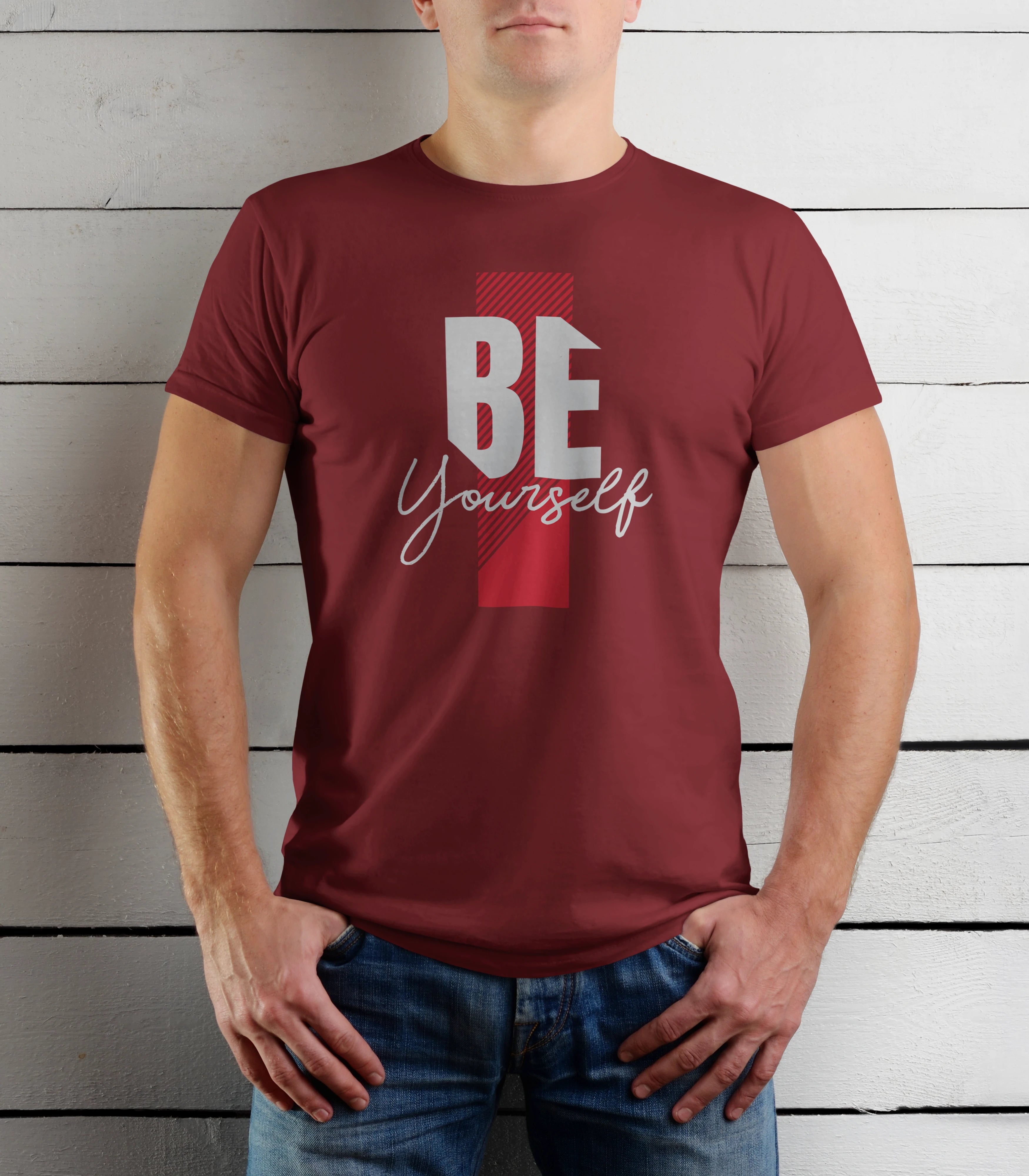 Person wearing a maroon t-shirt with 'BE Yourself' text against a wooden background